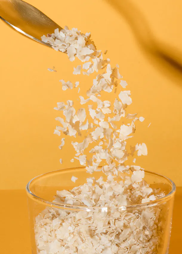 eine Schüssel Haferflocken wird in ein Glas gegossen