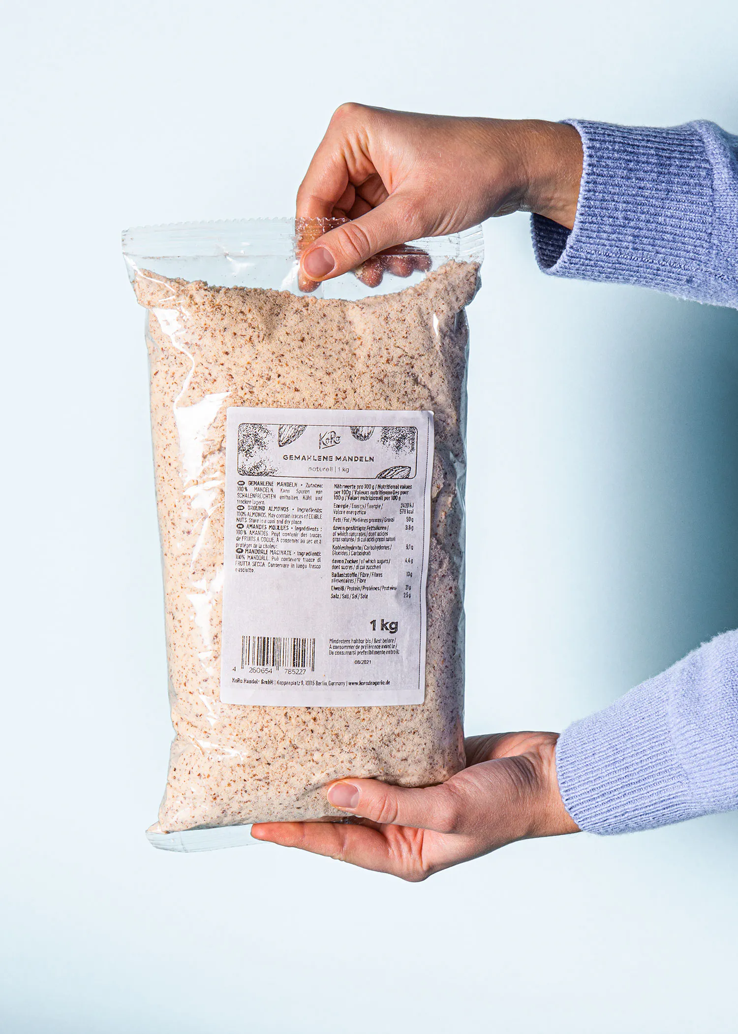 une personne tient un sac de farine de mandel de 1 kg