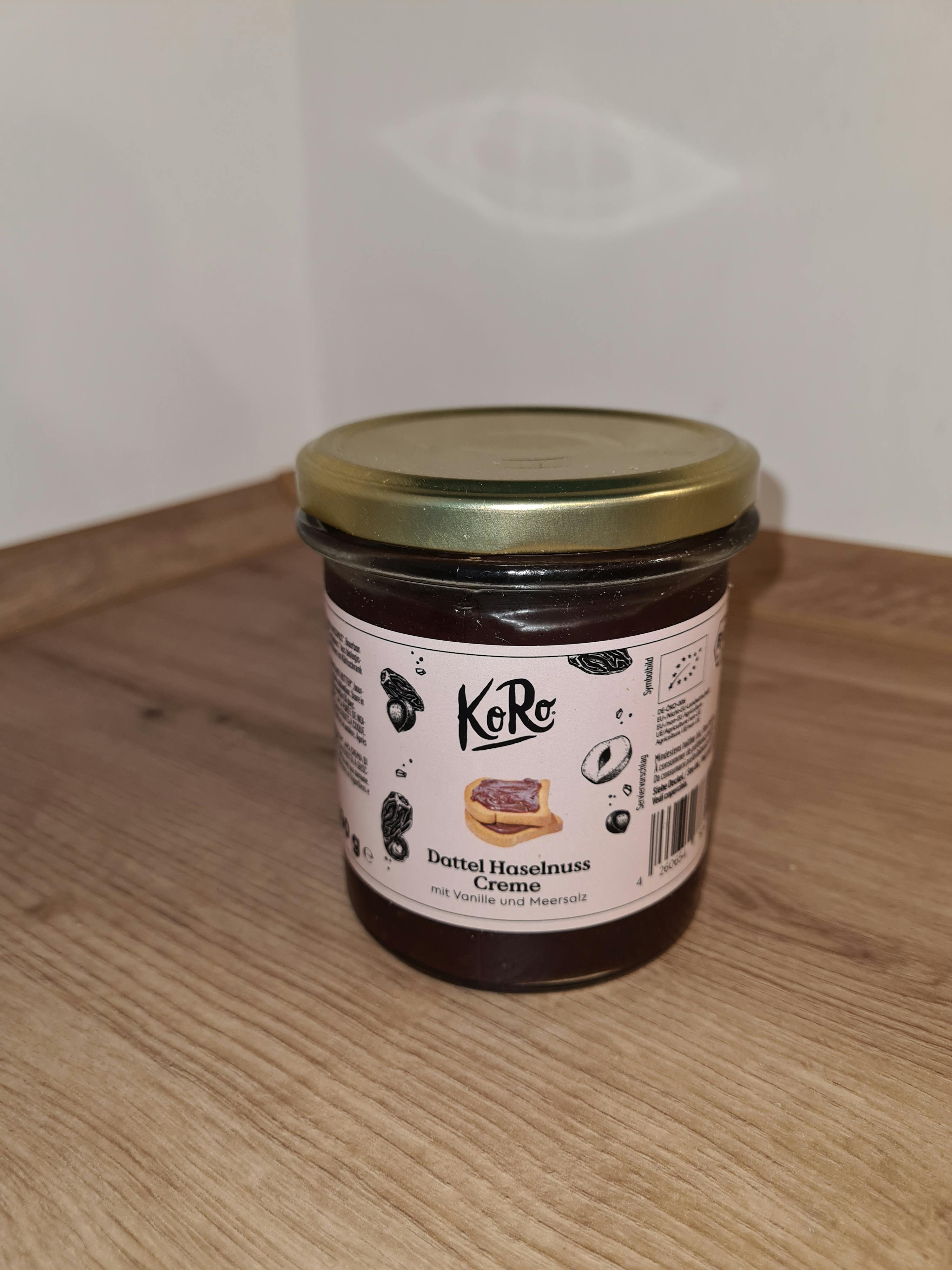 ein Glas dattel-Haselnuss-Creme liegt auf einem Holztisch