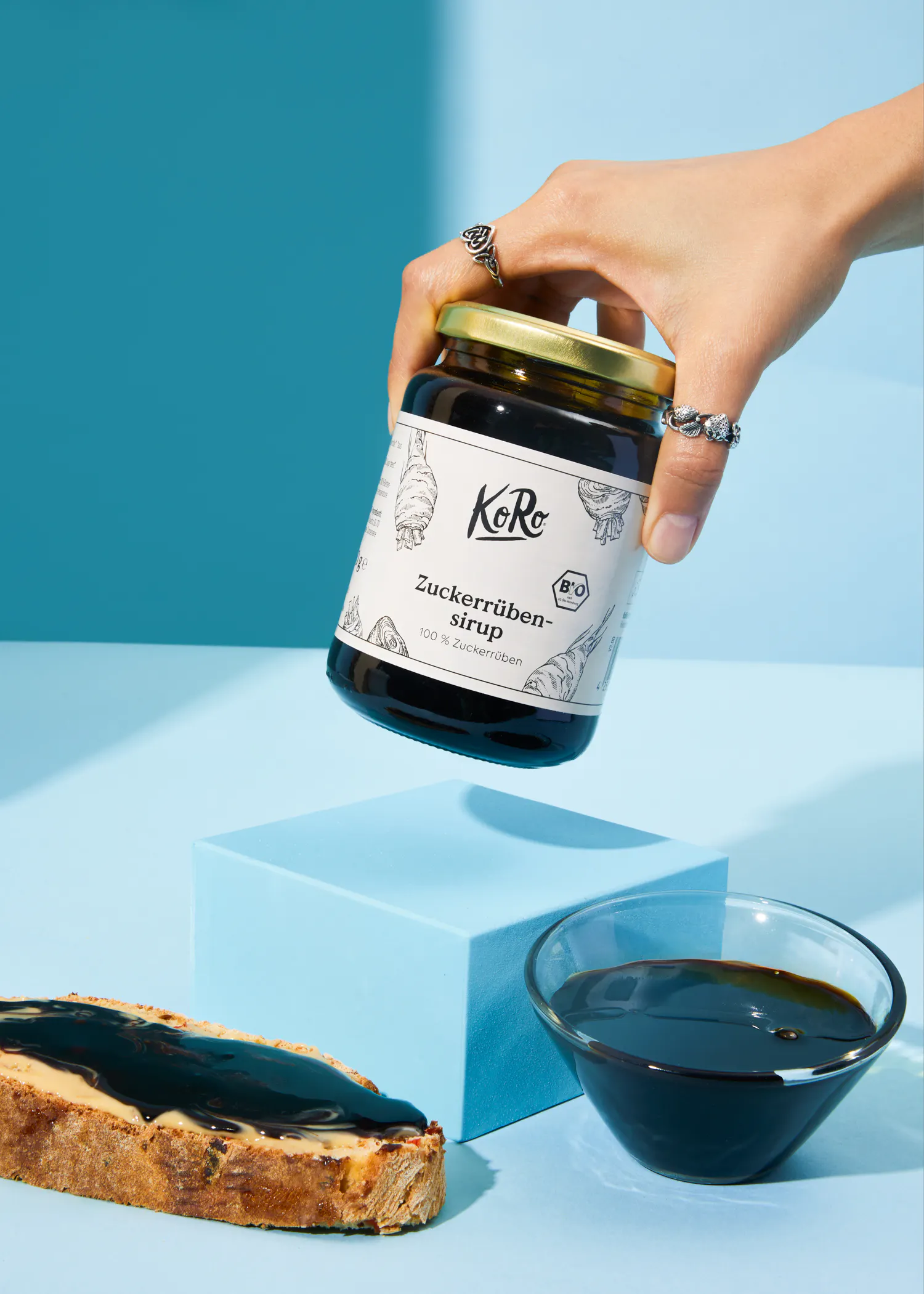 a person is holding a jar of zuckerrohren sirup