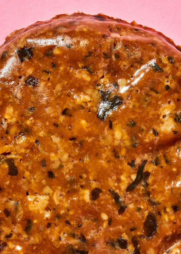 Eine Nahaufnahme eines Stücks Essen auf einem rosa Hintergrund