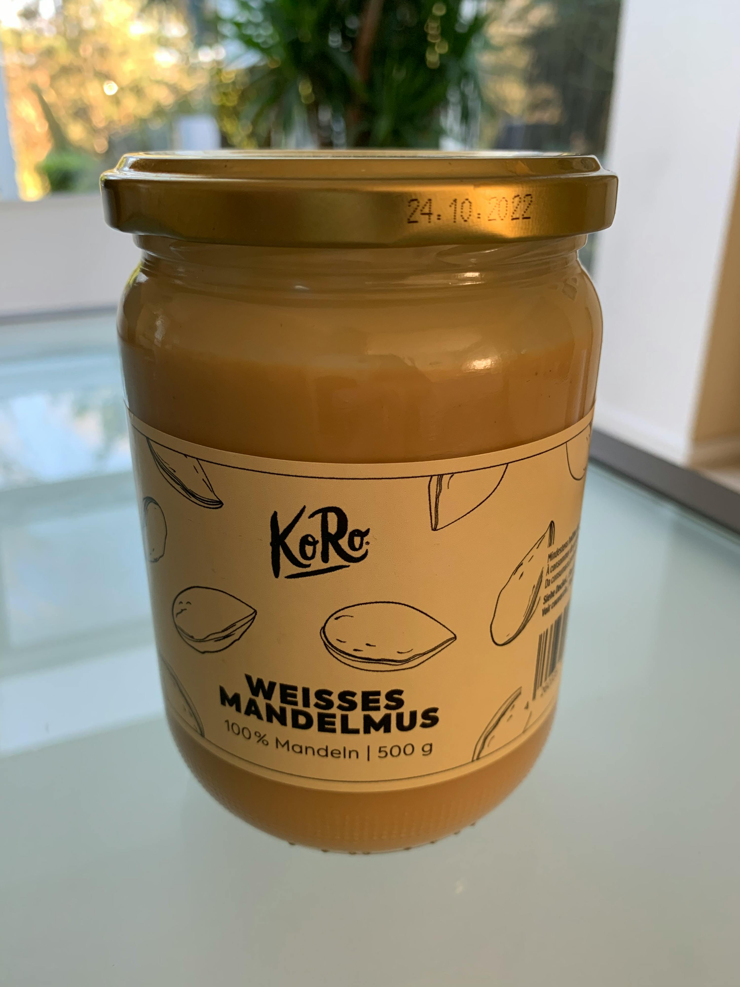 un barattolo di burro di mandorle bianche è su un tavolo