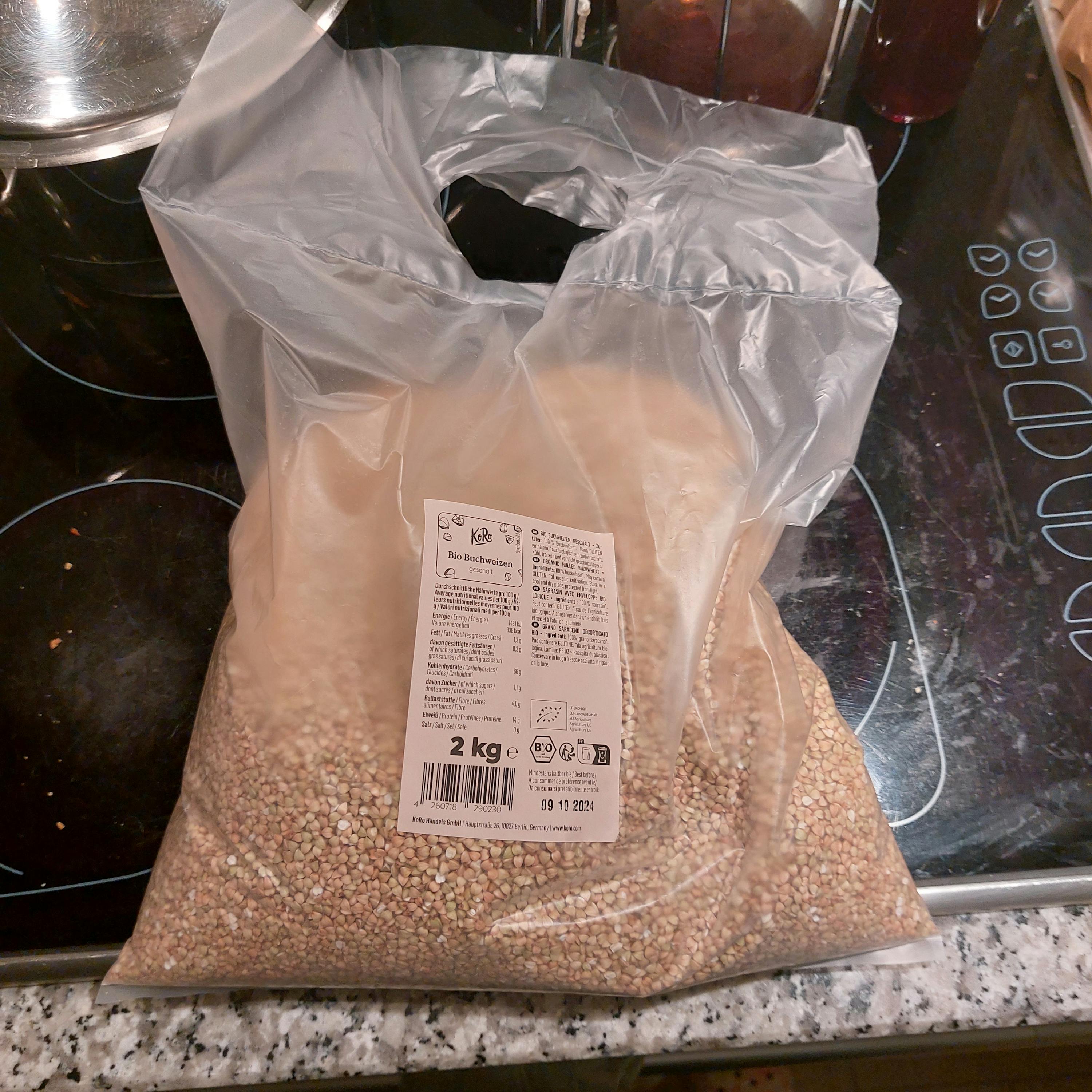 un sacchetto di grano è seduto su un tavolo accanto a un sacchetto di plastica