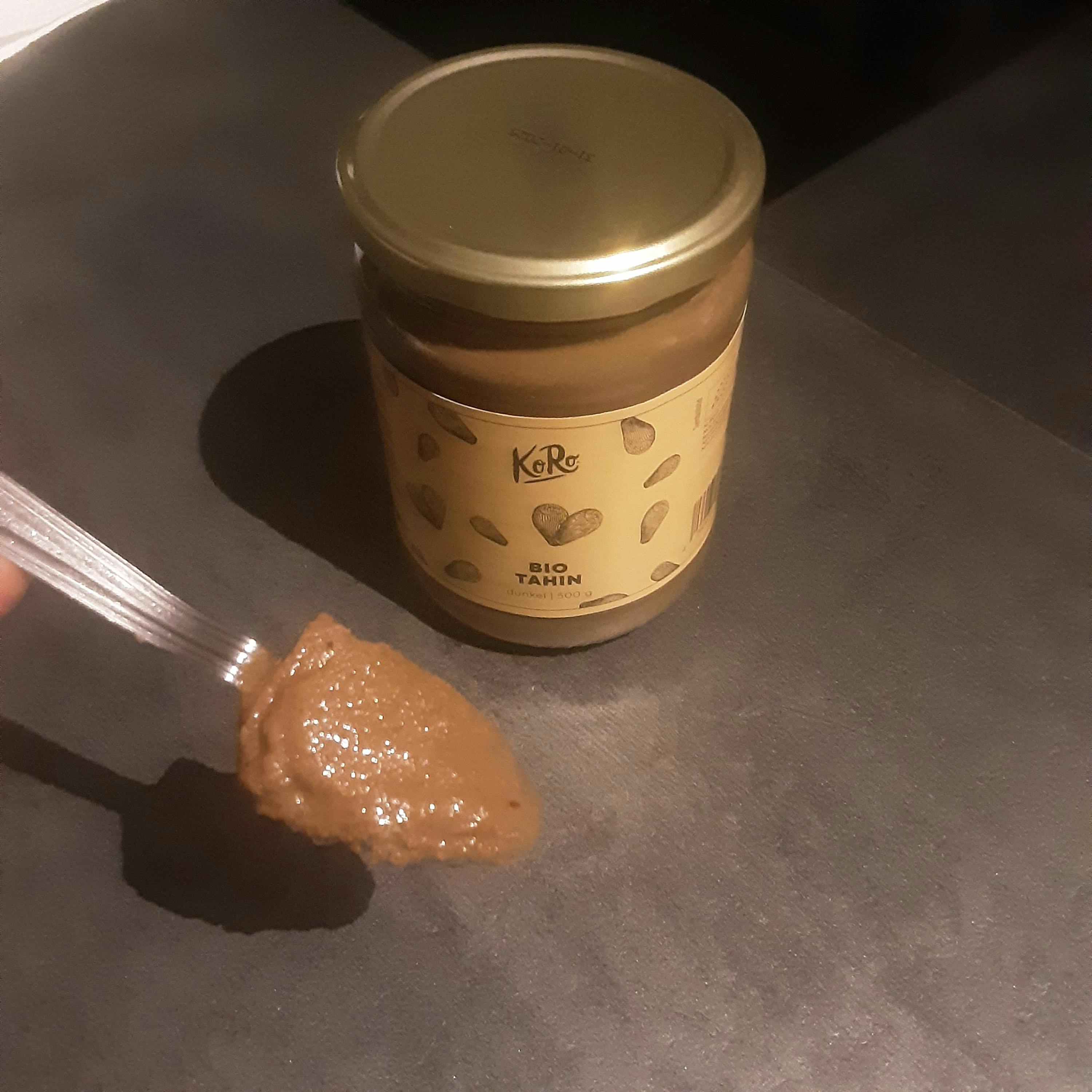 a jar of peanut butter sits next to a spoon