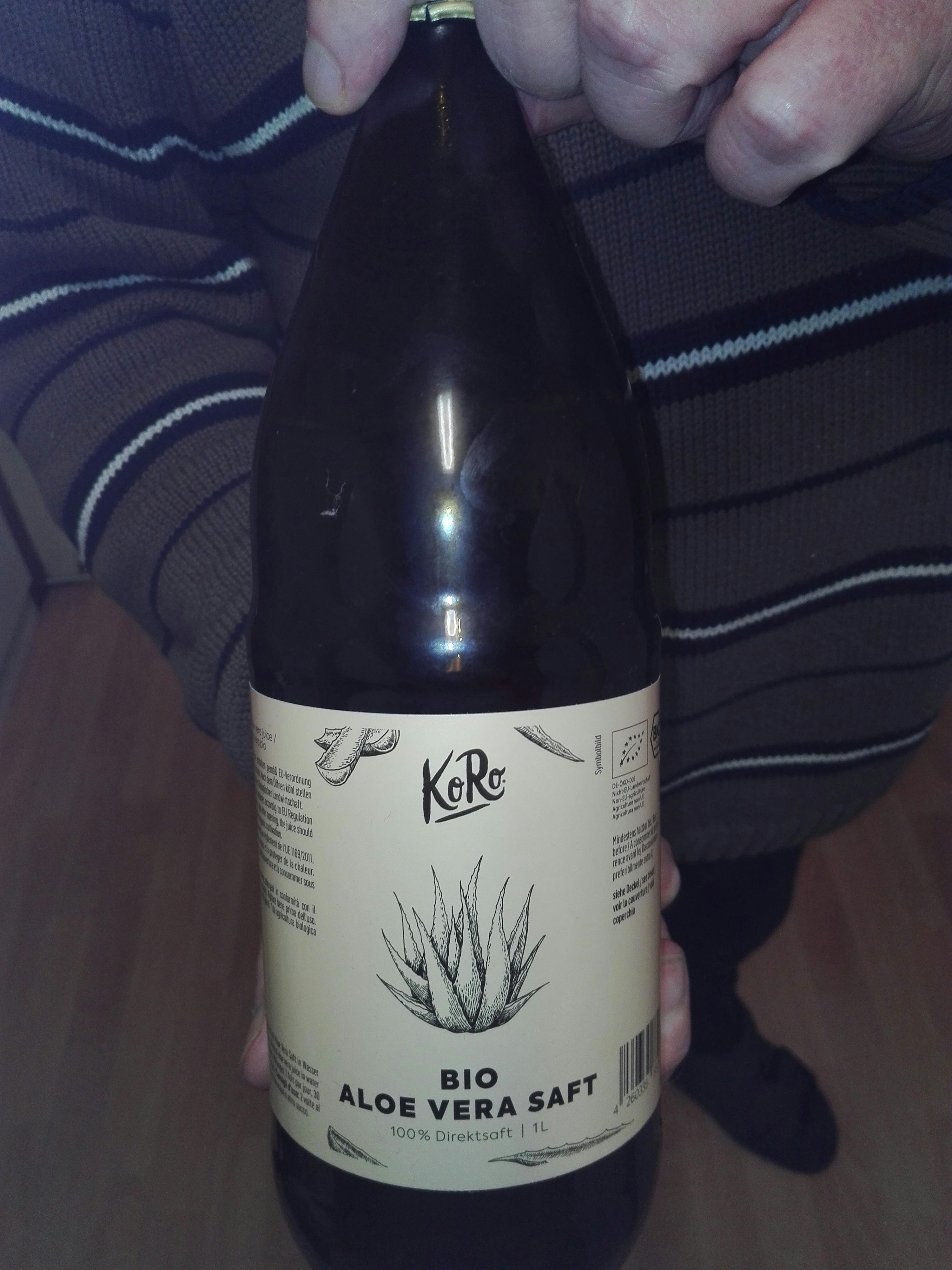 a person holding a bottle of bio aloe vera saft