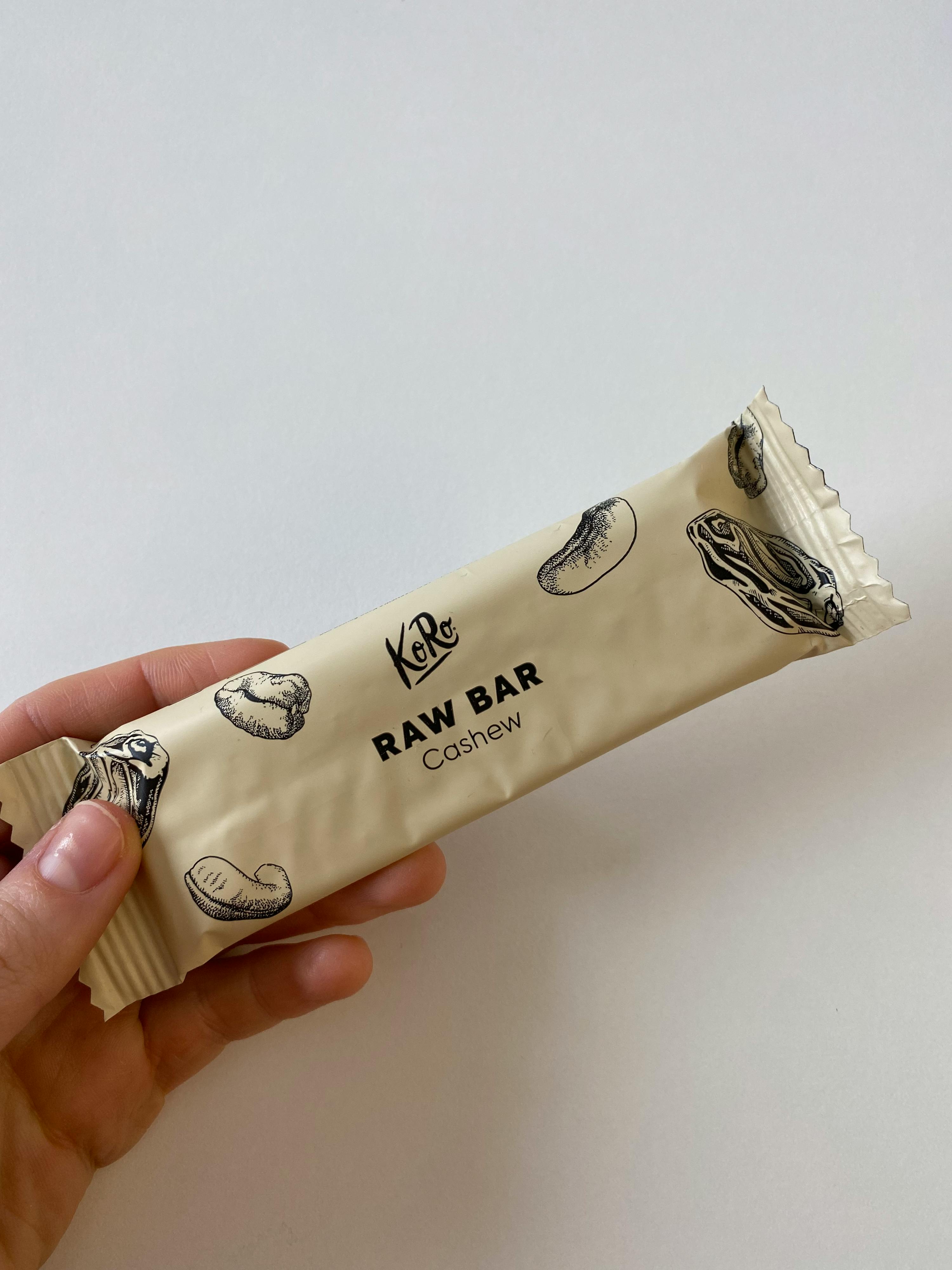una persona tiene in mano una barretta raw bar cashew