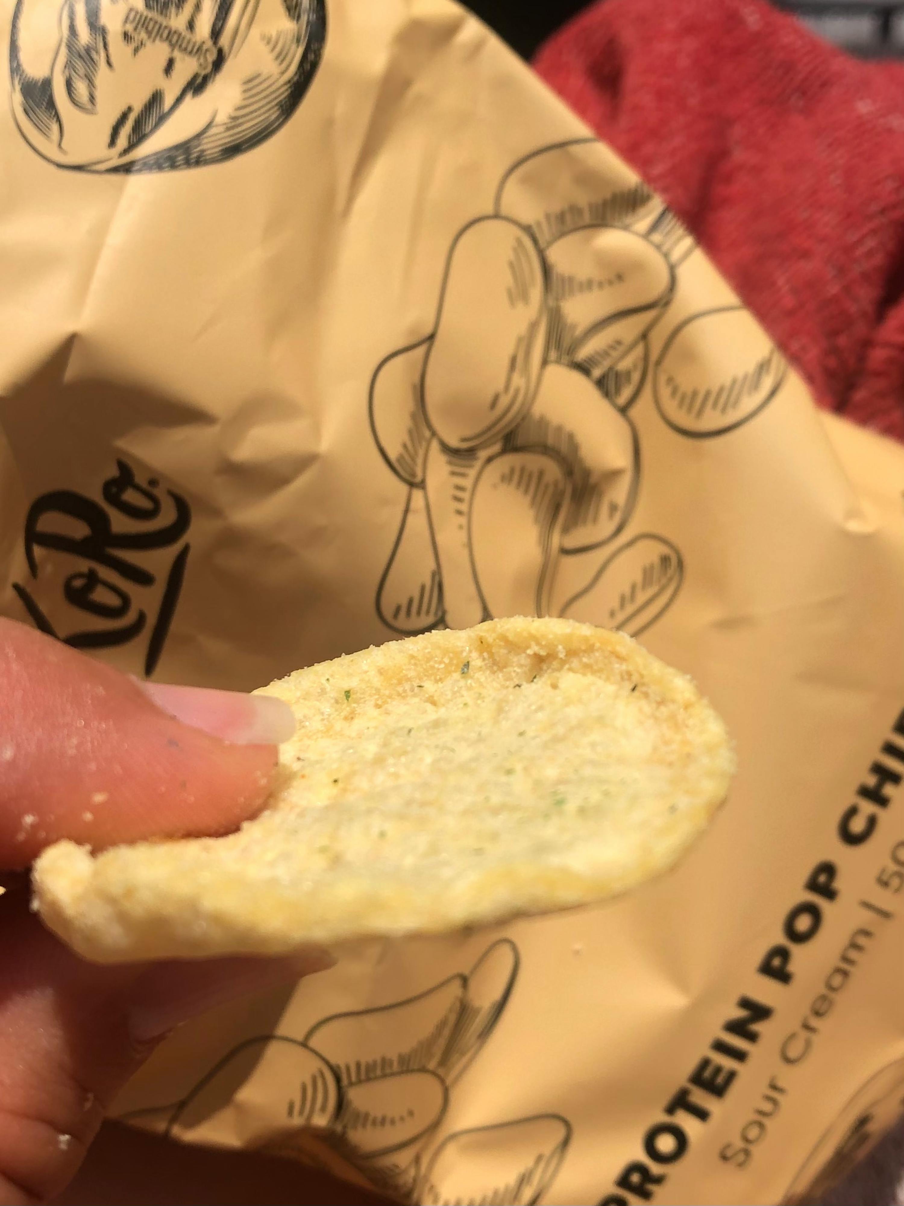 Eine Person hält ein Stück Kartoffelchips in der Hand