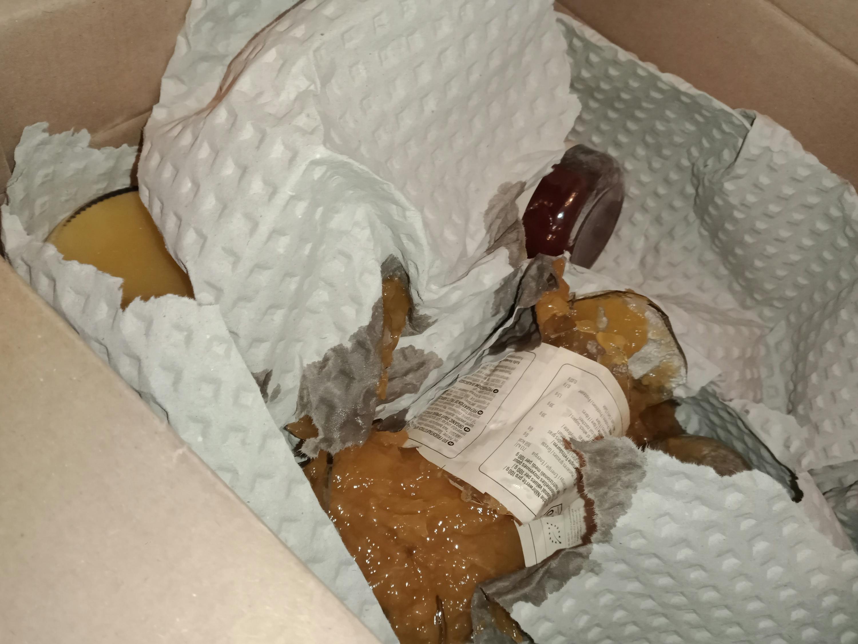 une bouteille de ketchup est assise dans une boîte enveloppée de papier d' emballage