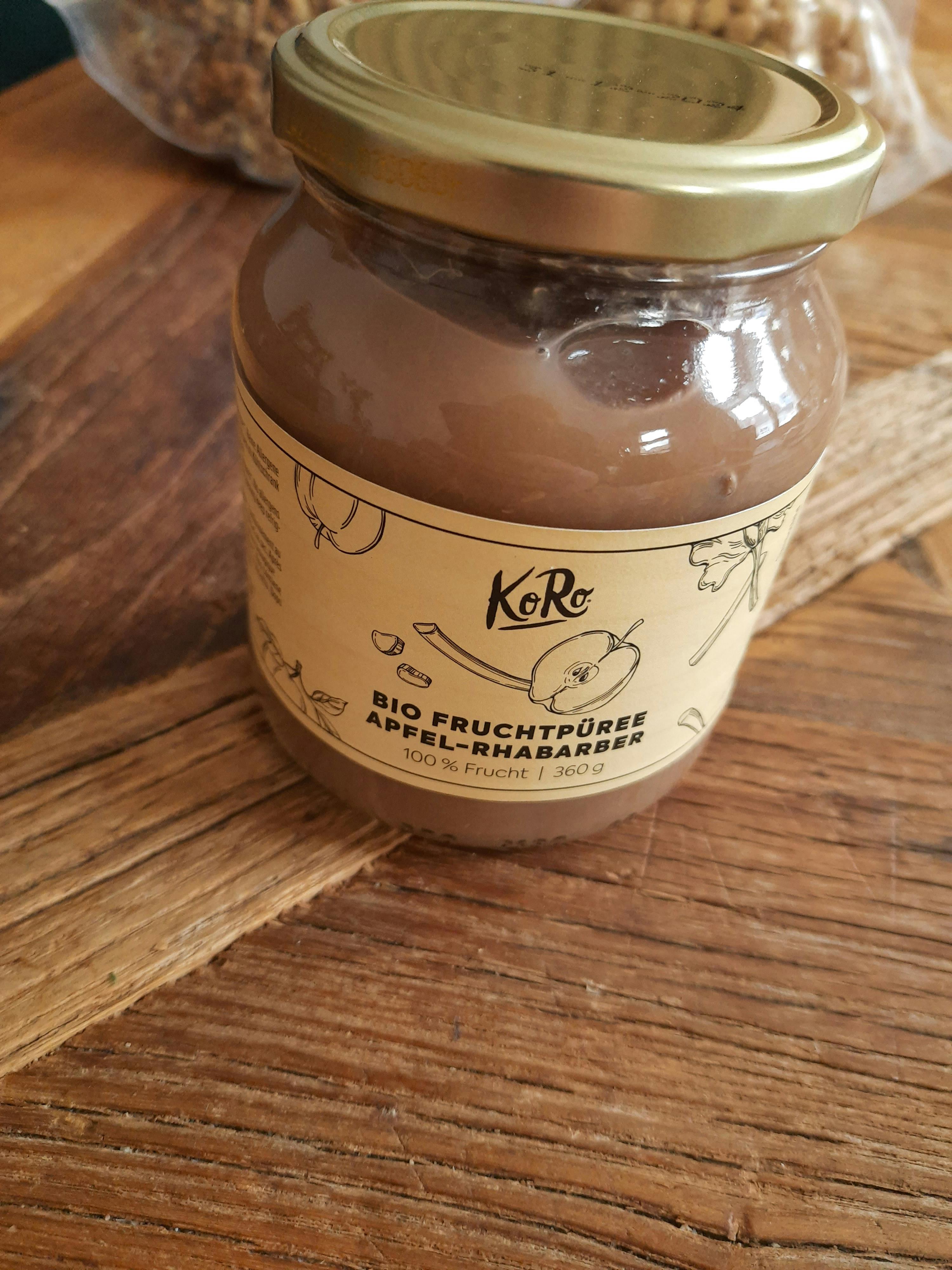 un barattolo di marmellata di mele bio è seduto su un tavolo di legno