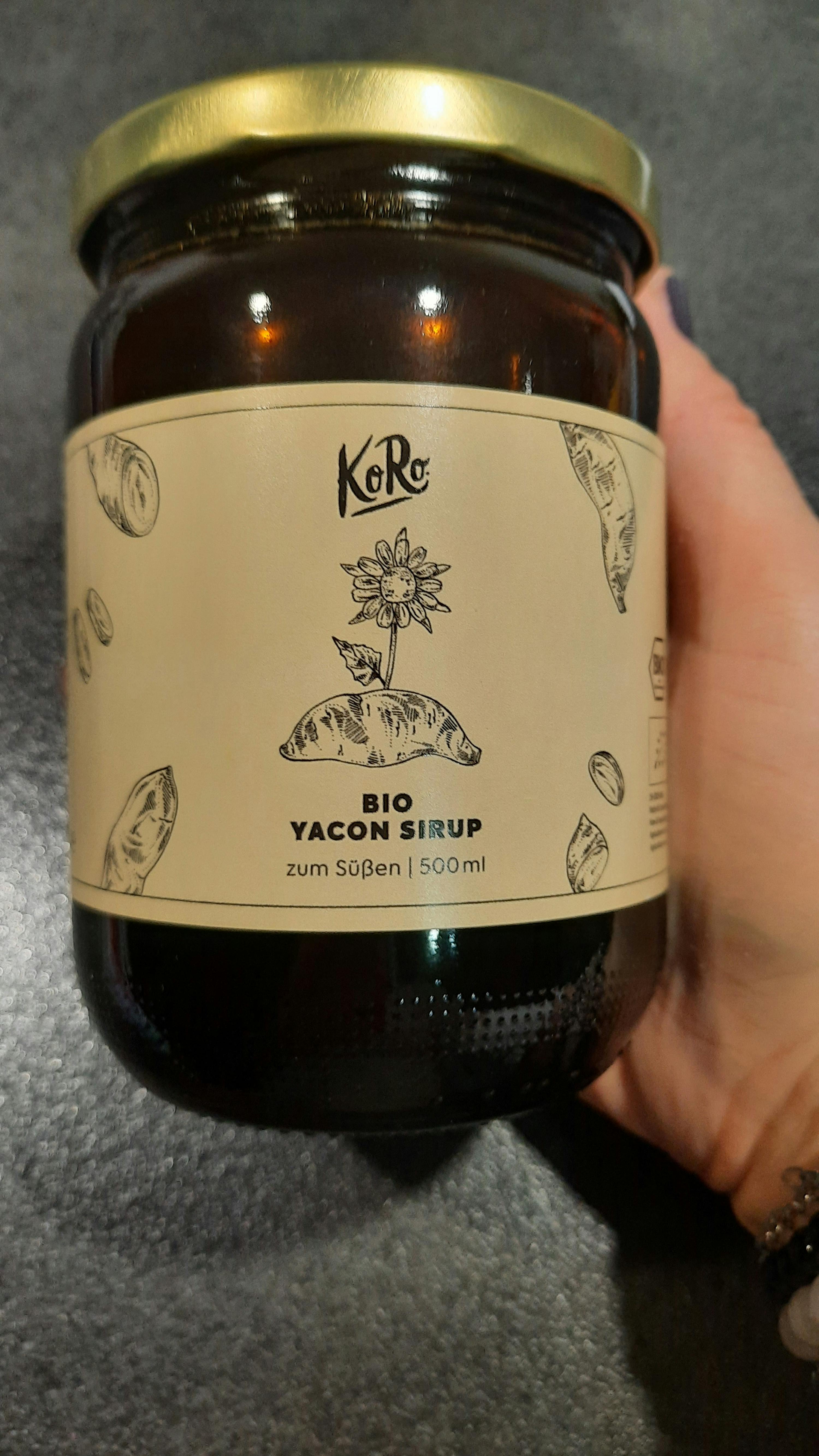 une personne tient un bocal de sirop yacon bio