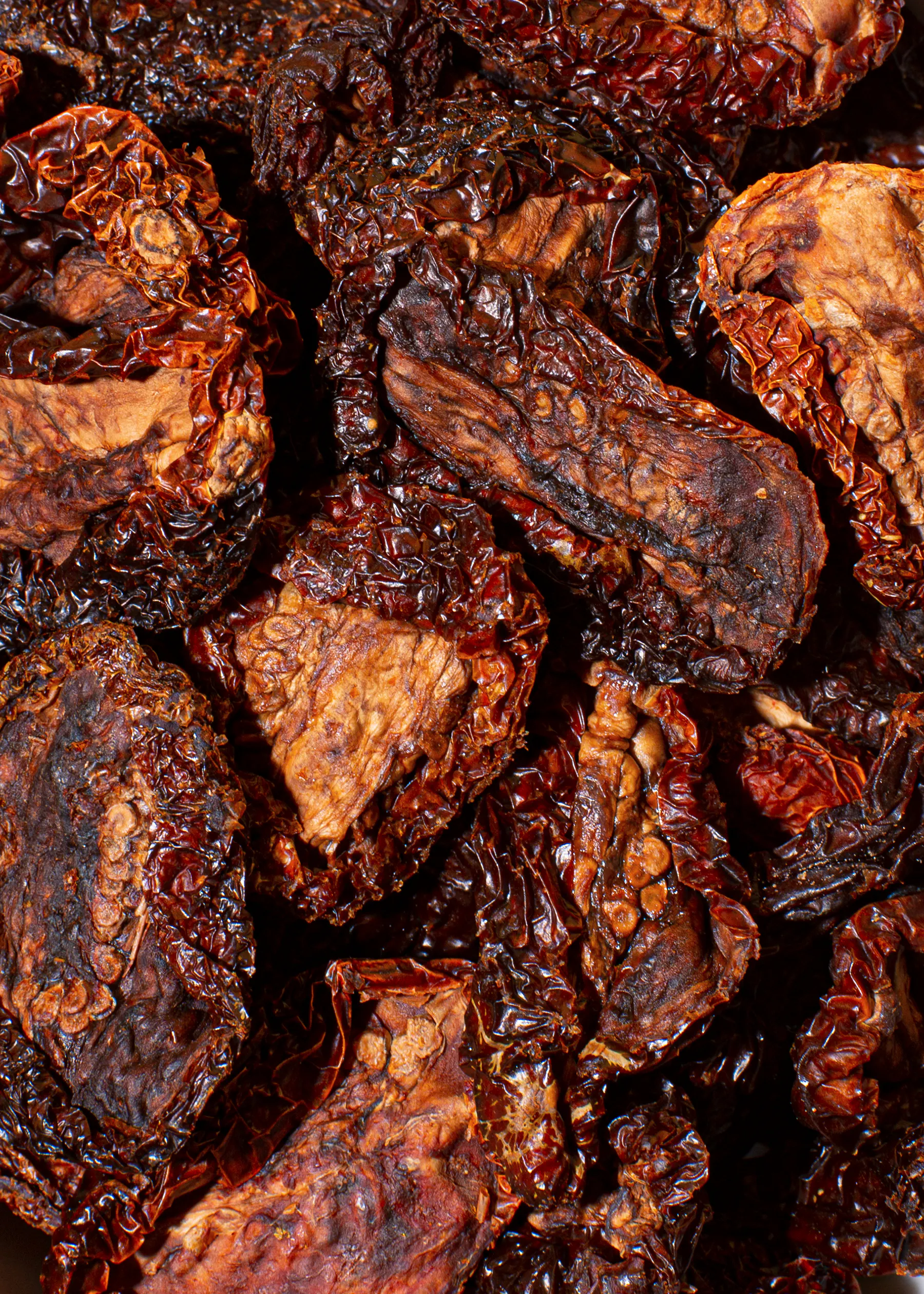 a pile of dried tomatoes with a few pieces missing