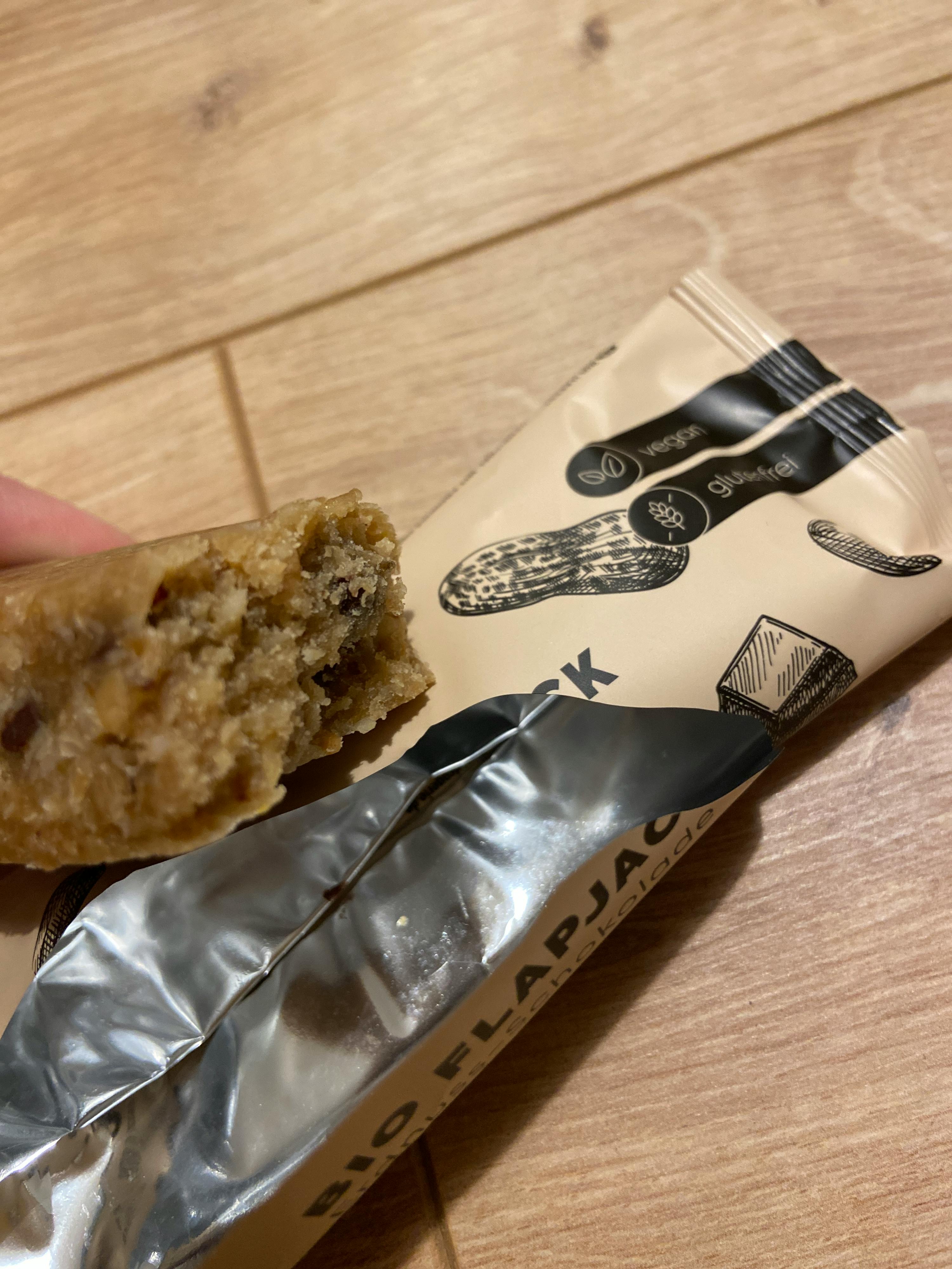 une personne tient une barre de céréales bio flapack