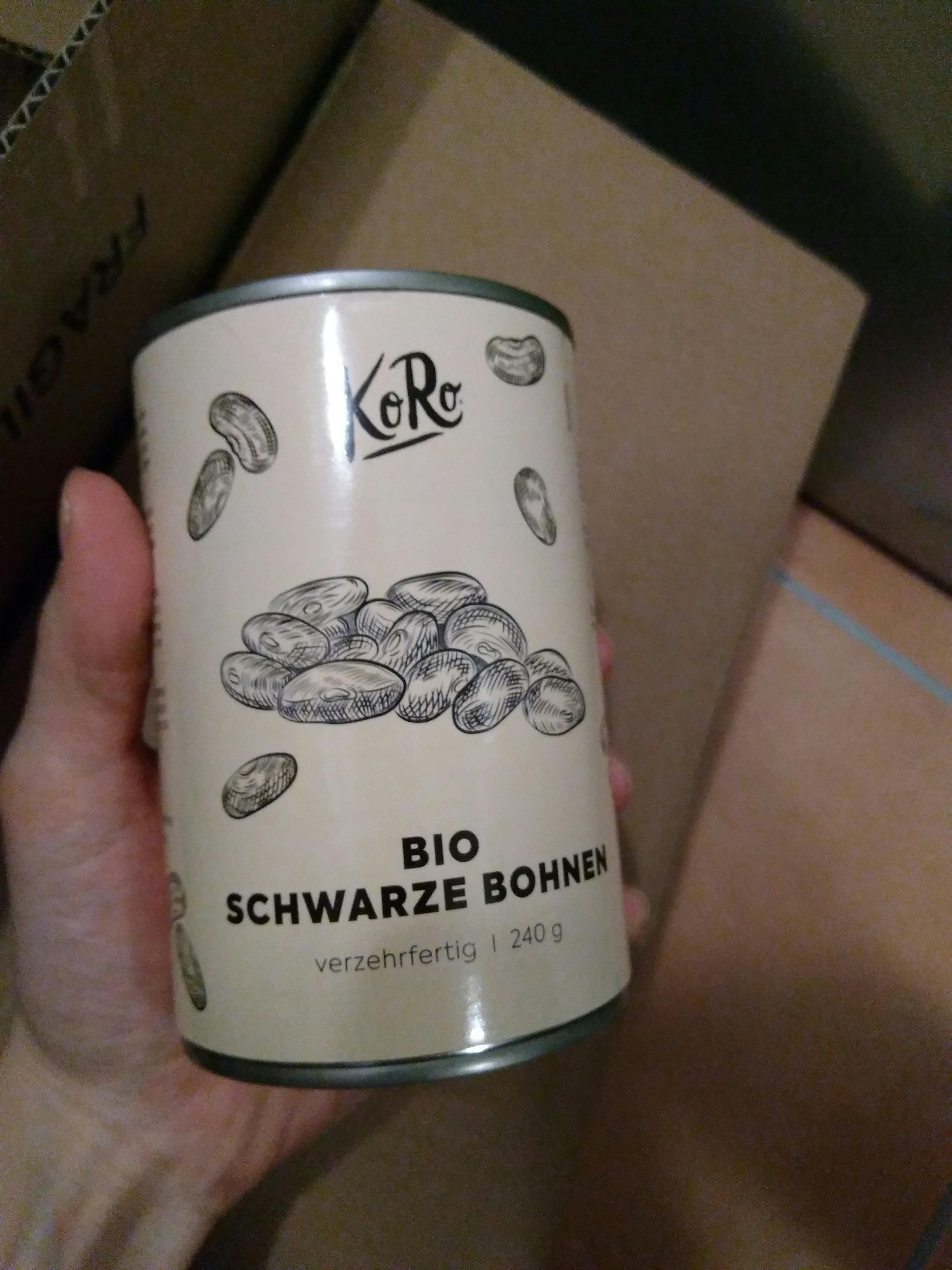 una persona tiene in mano una lattina di fagioli neri biologici