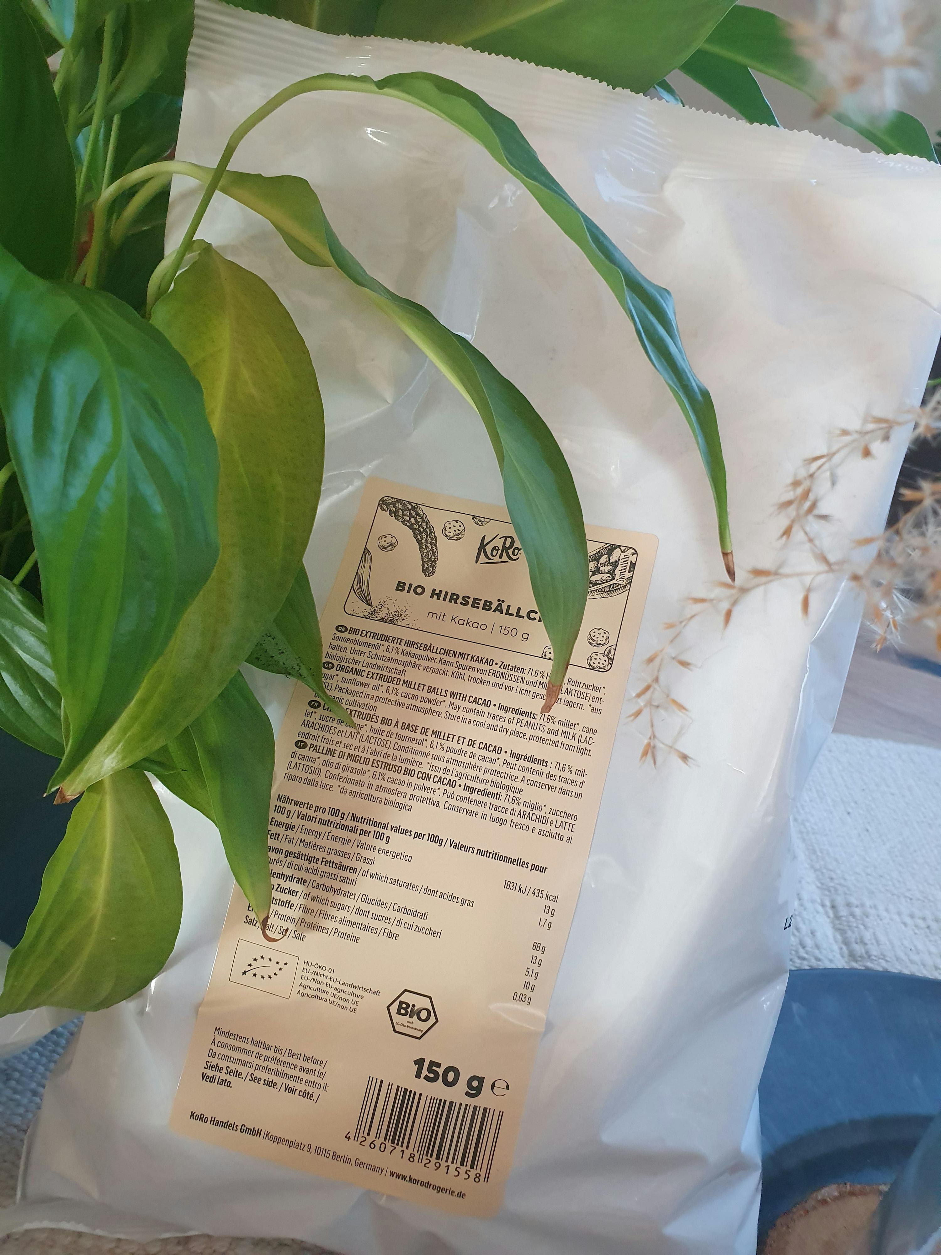 eine verpackte pflanze neben einem beutel bio hirsbällchen