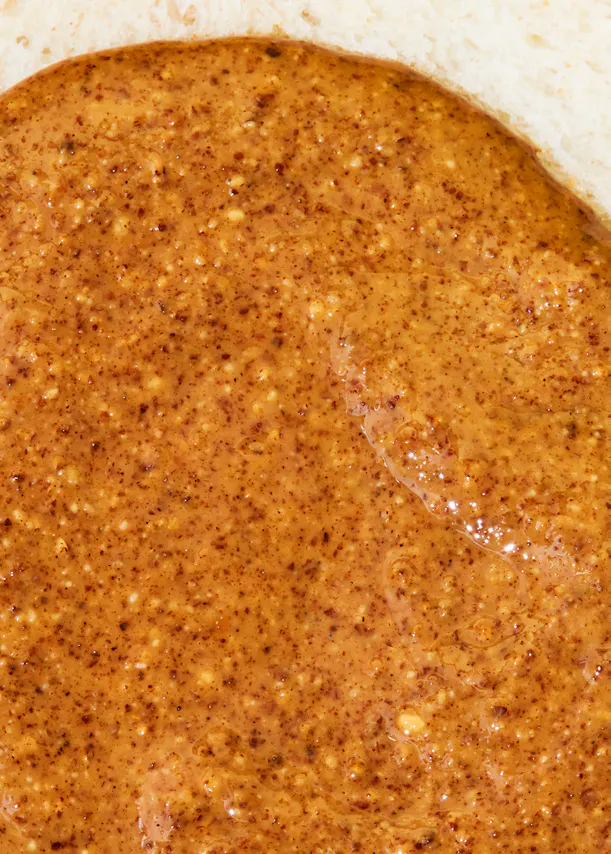 un gros plan d' une sauce brune avec des graines