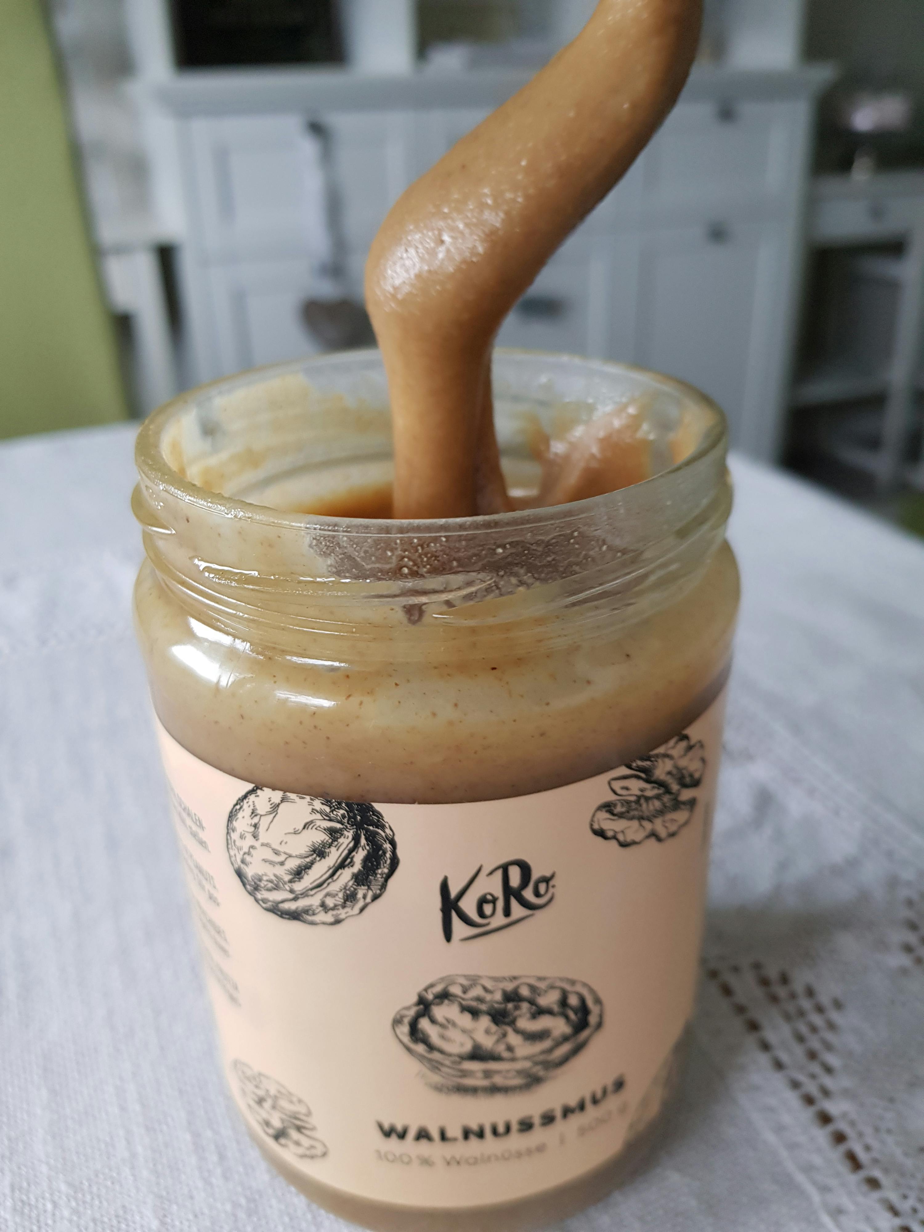 a jar of walnut spread has a spoon sticking out of it