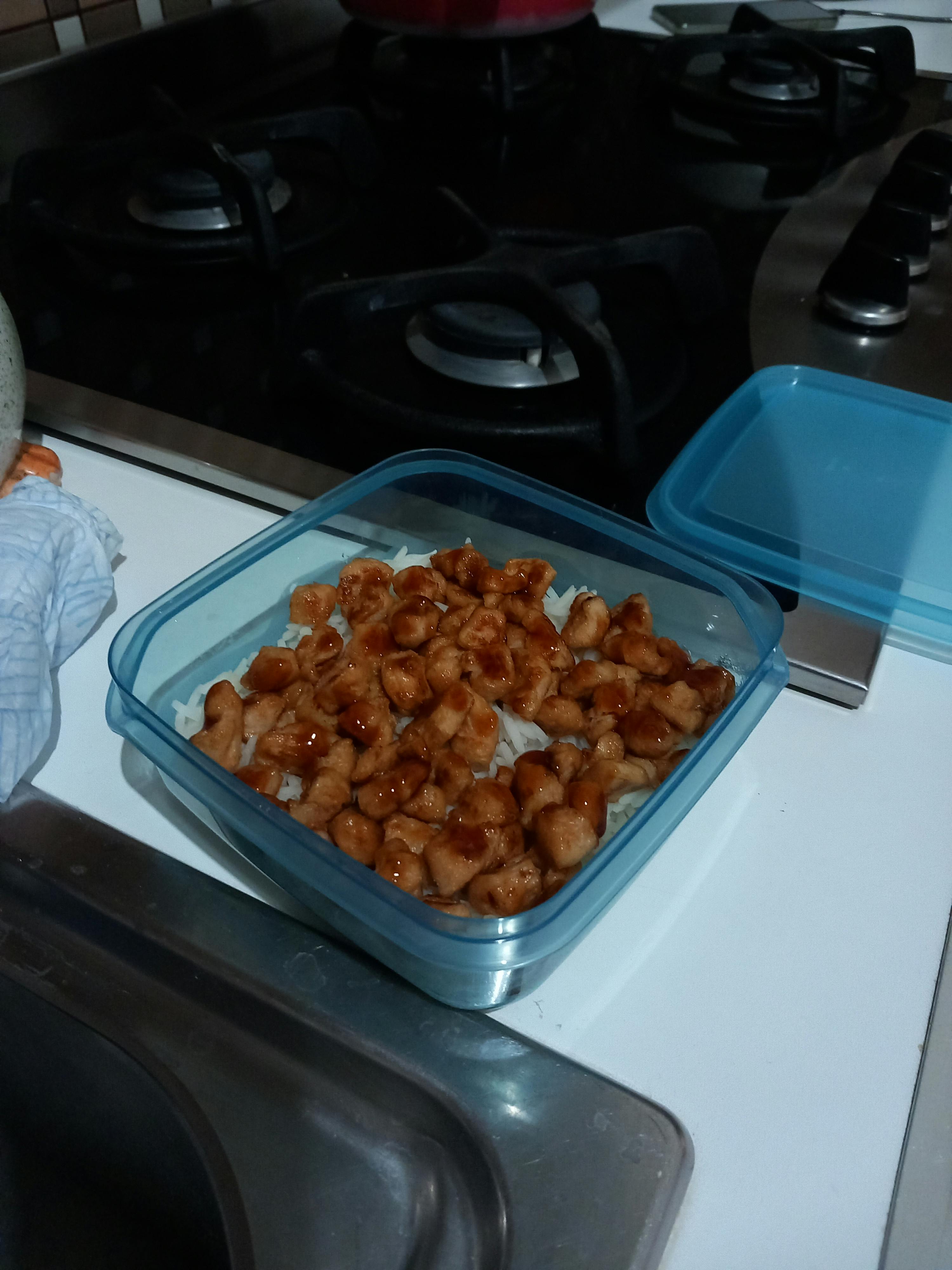 un récipient en plastique rempli de nourriture sur une cuisinière