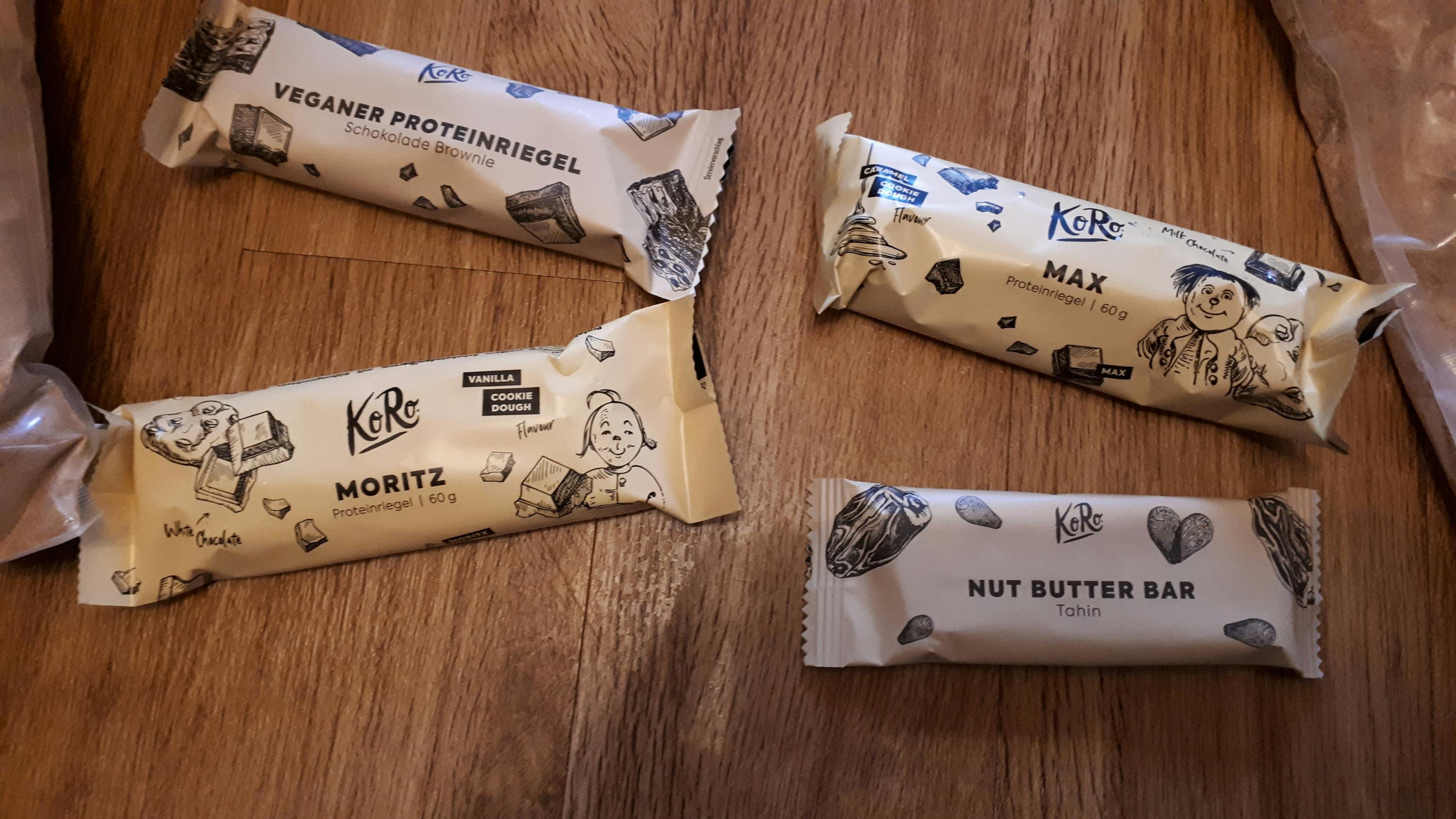 four different flavors of kore bars are lined up on a wooden table