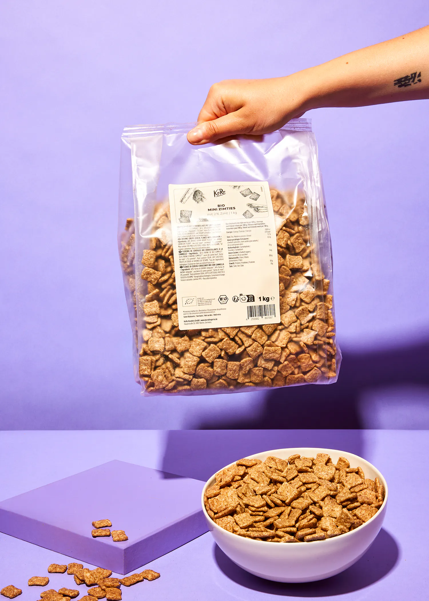 une personne tient un sac de céréales près d' un bol de céréales