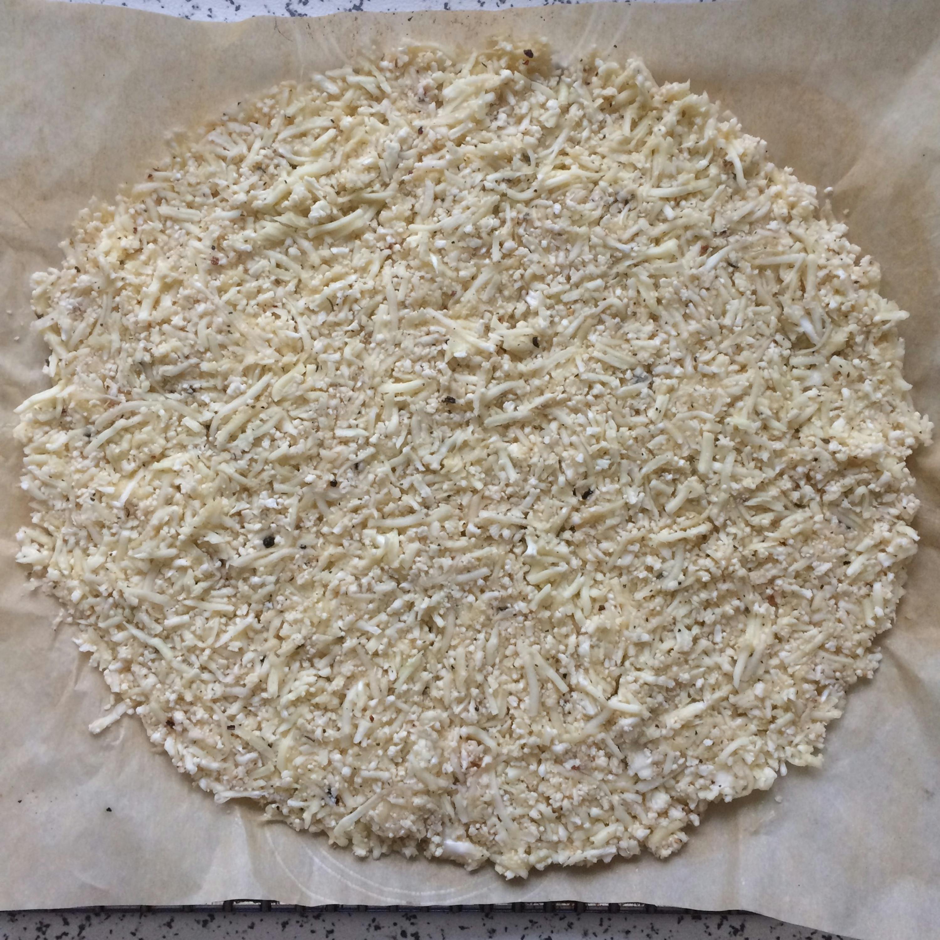 una pizza ricoperta di formaggio è seduta su un foglio di carta