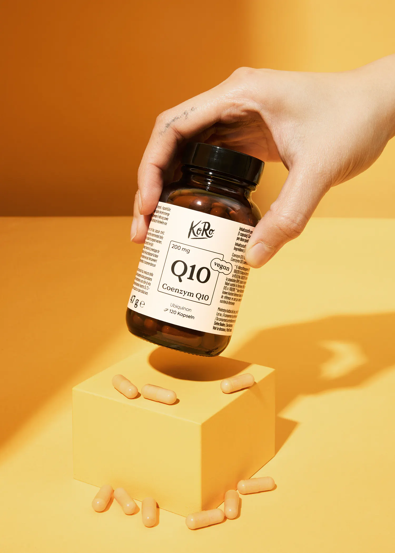 a person is holding a bottle of coenzyme q10