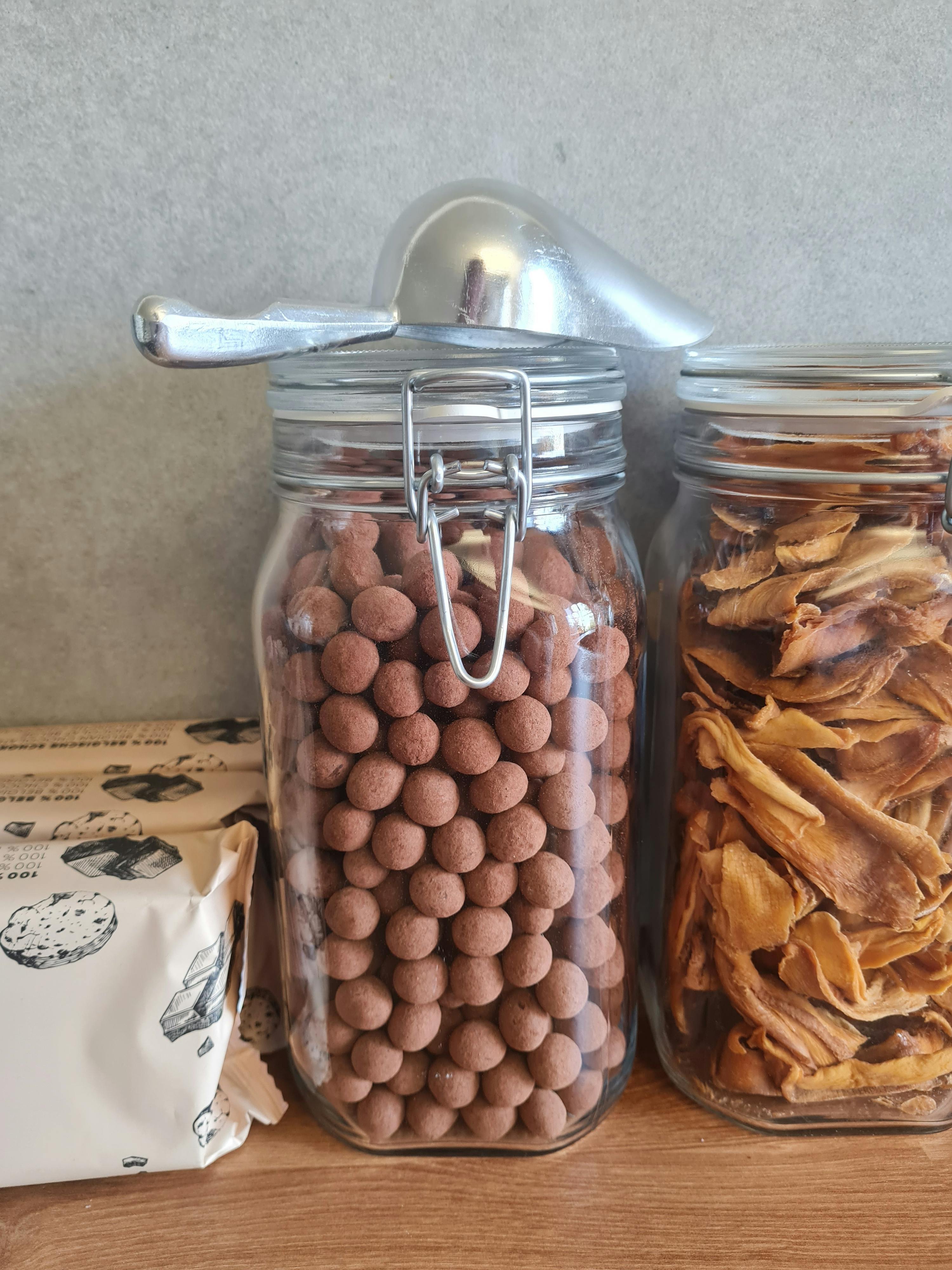 ein Glas mit Schokoladenkugeln und ein Glas mit getrockneten Äpfeln