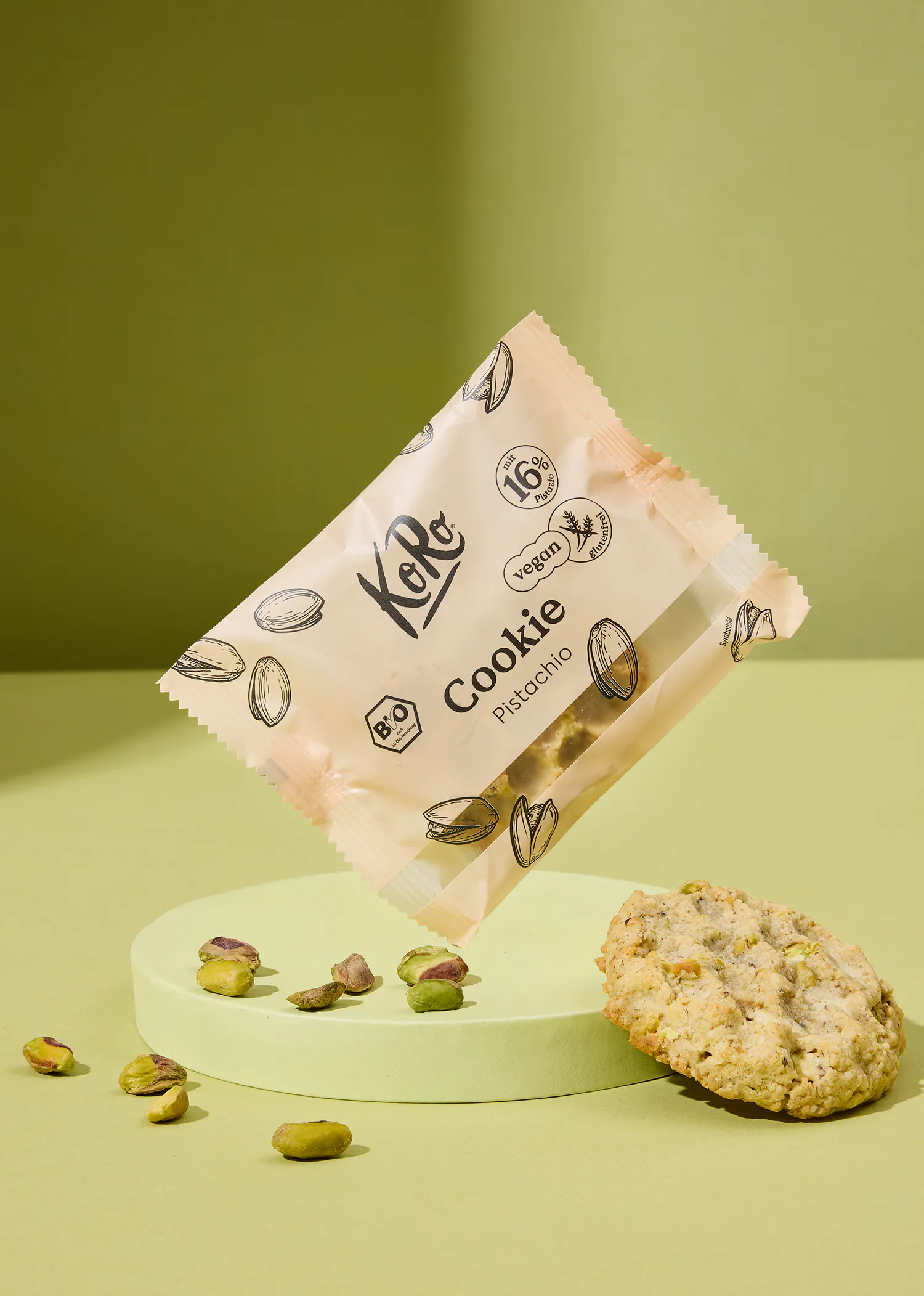 un paquet de biscuits à la pistache est posé sur une surface verte