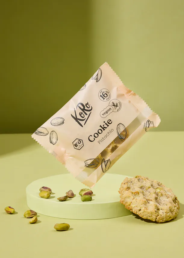 un paquet de biscuits à la pistache est posé sur une surface verte