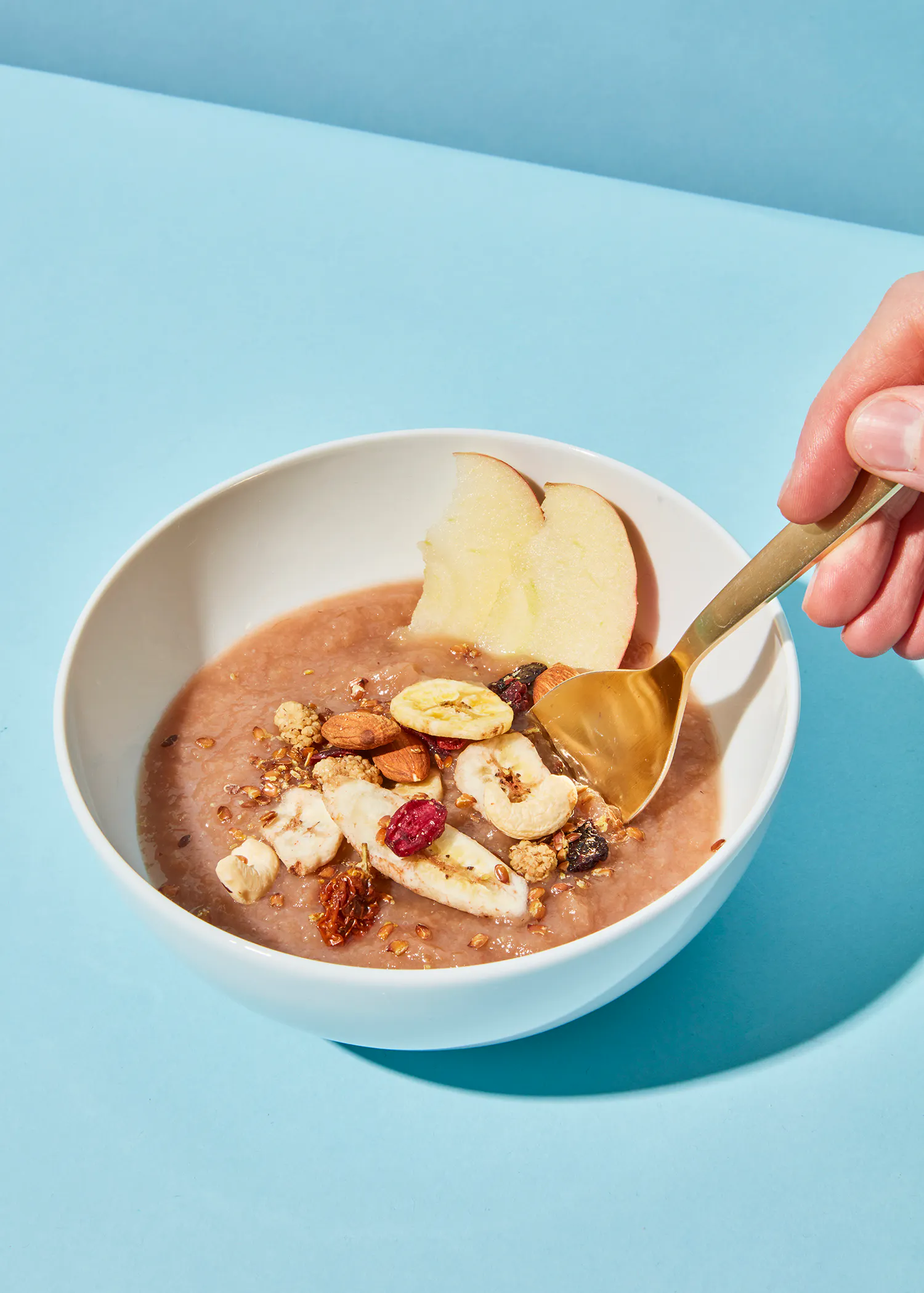 Person , die einen Löffel in eine Schüssel mit Müsli hält