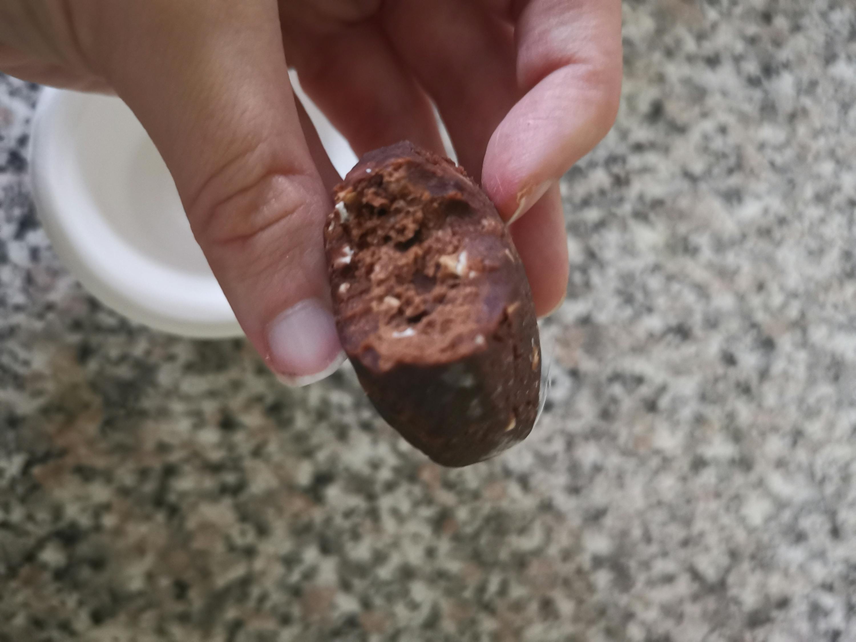 eine Person hält einen Schokoladenbällchen in der Hand