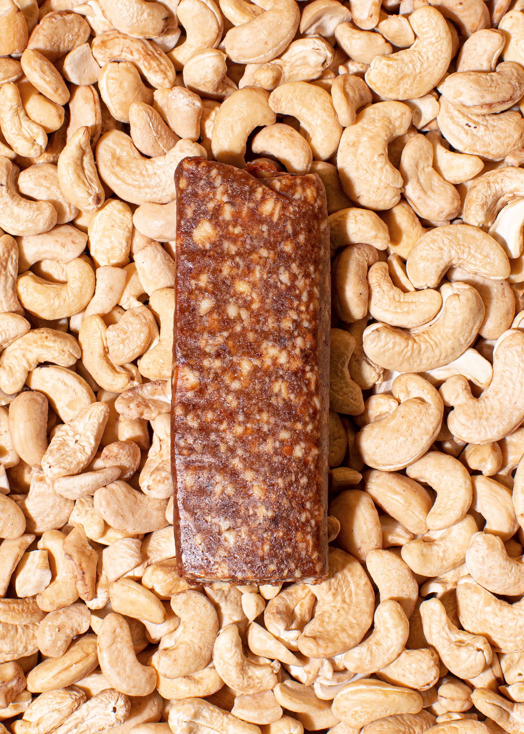 une barre de nourriture est posée sur un tas de noix de cajou