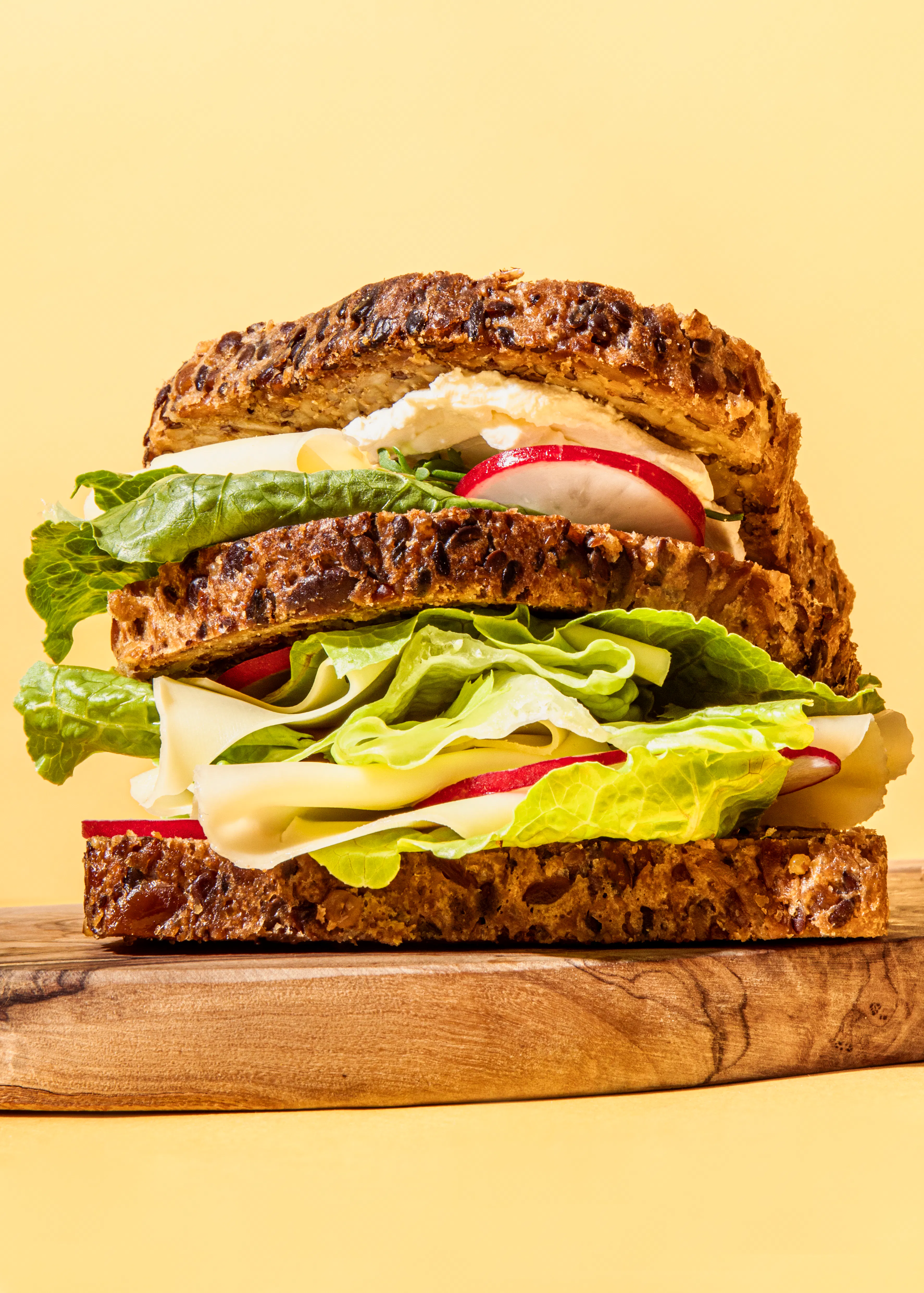 ein Sandwich mit Salat und Eiern auf einem Schneidebrett