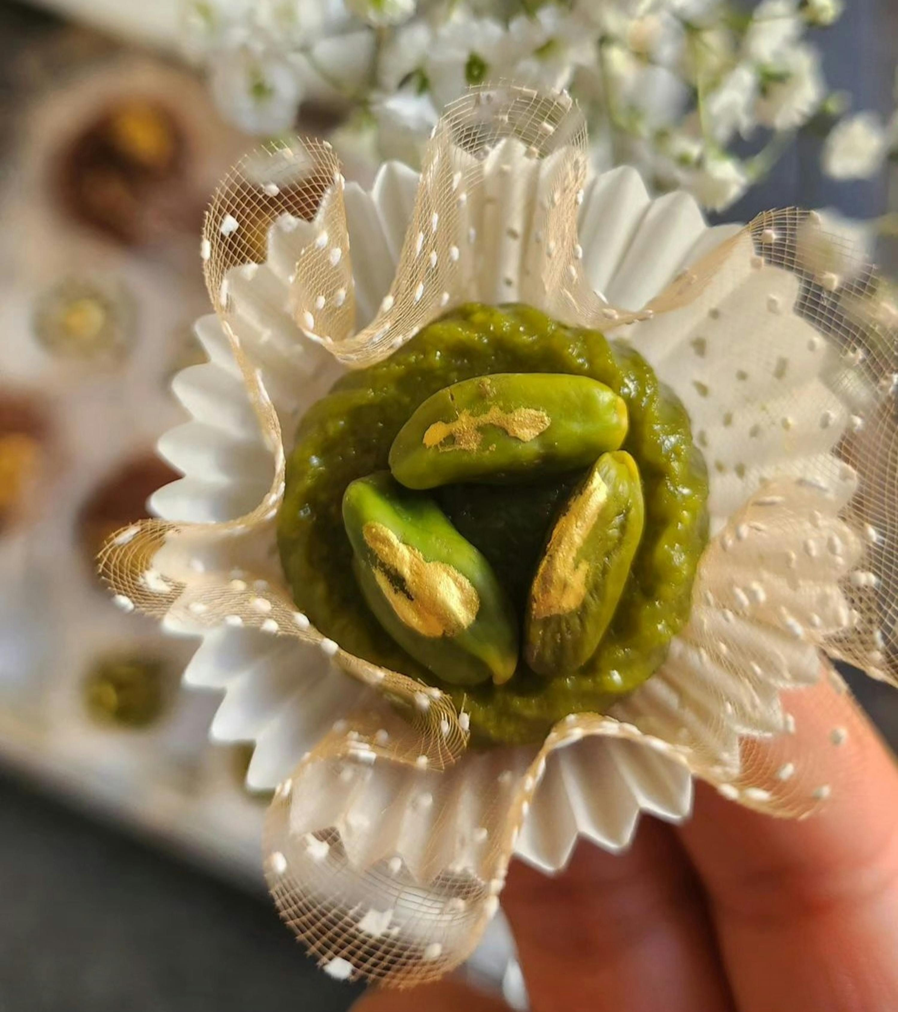 eine Person hält einen grünen Dessert in einer weißen Blume