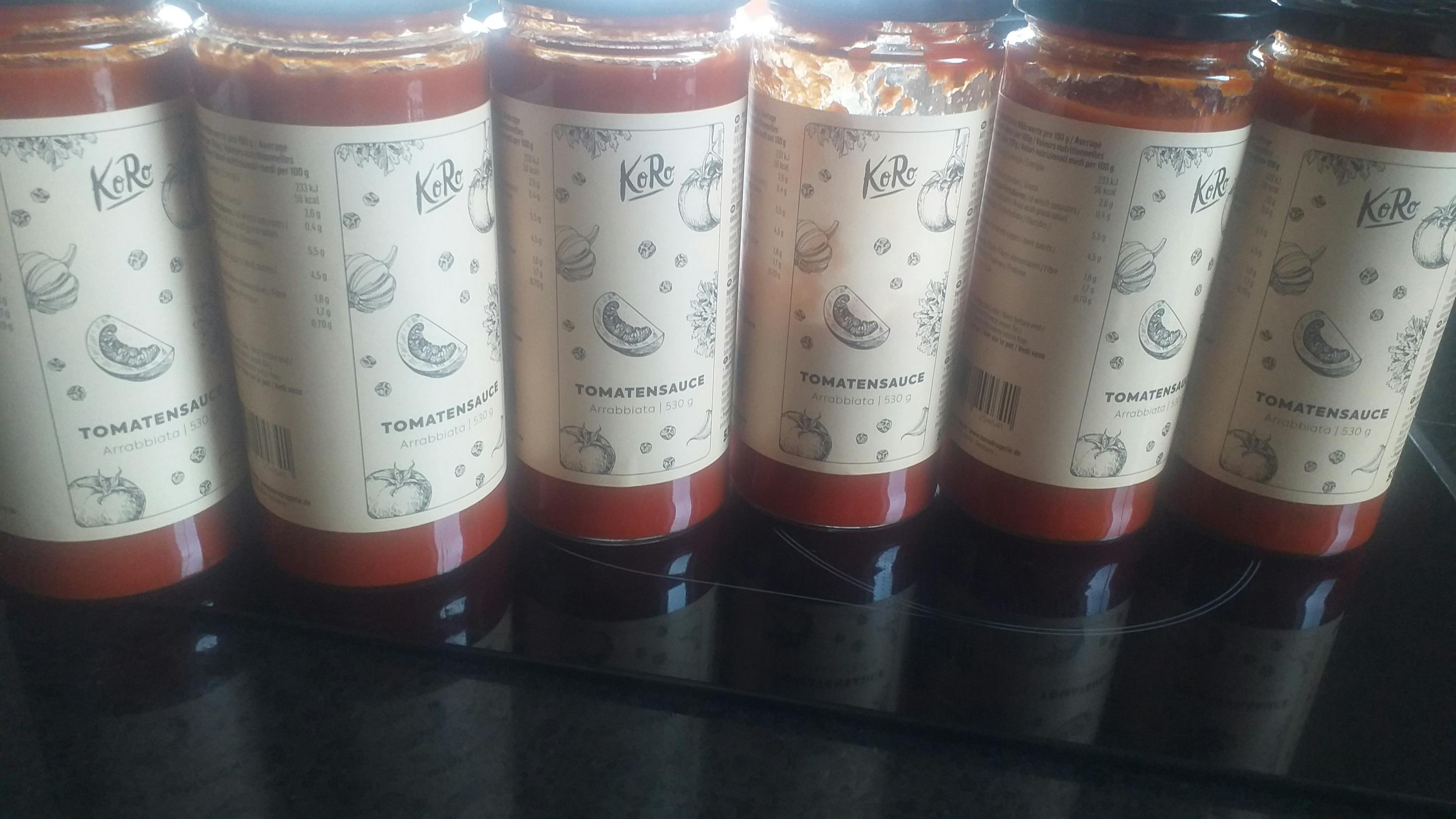 several jars of tomato sauce are lined up on a counter