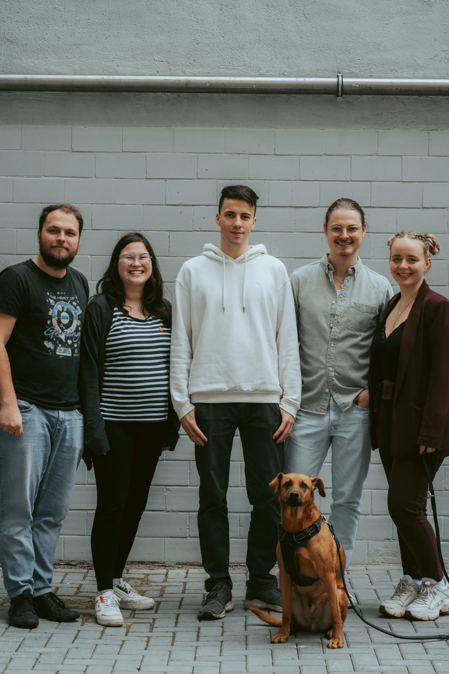 un groupe de personnes debout l' une à côté de l' autre avec un chien