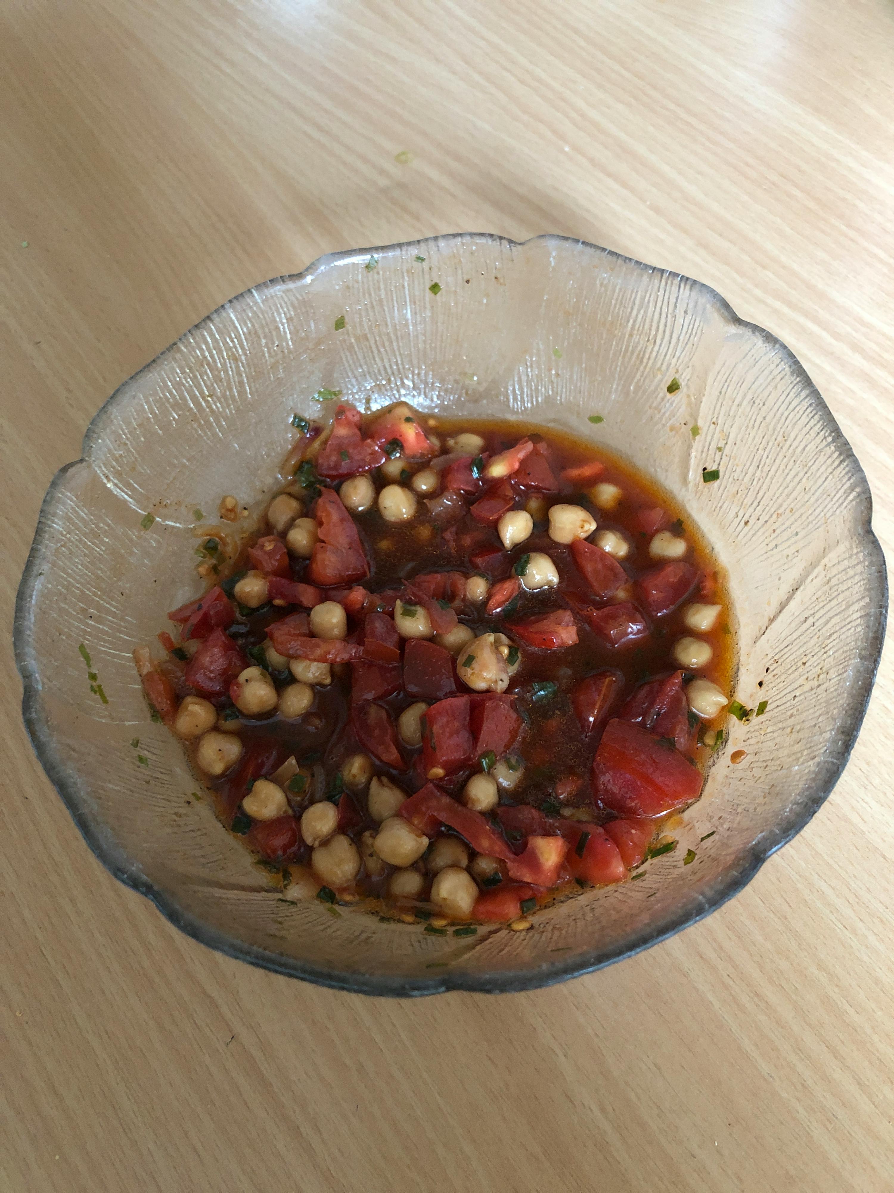 eine Glasschale mit Gemüse und Soße auf einem Tisch