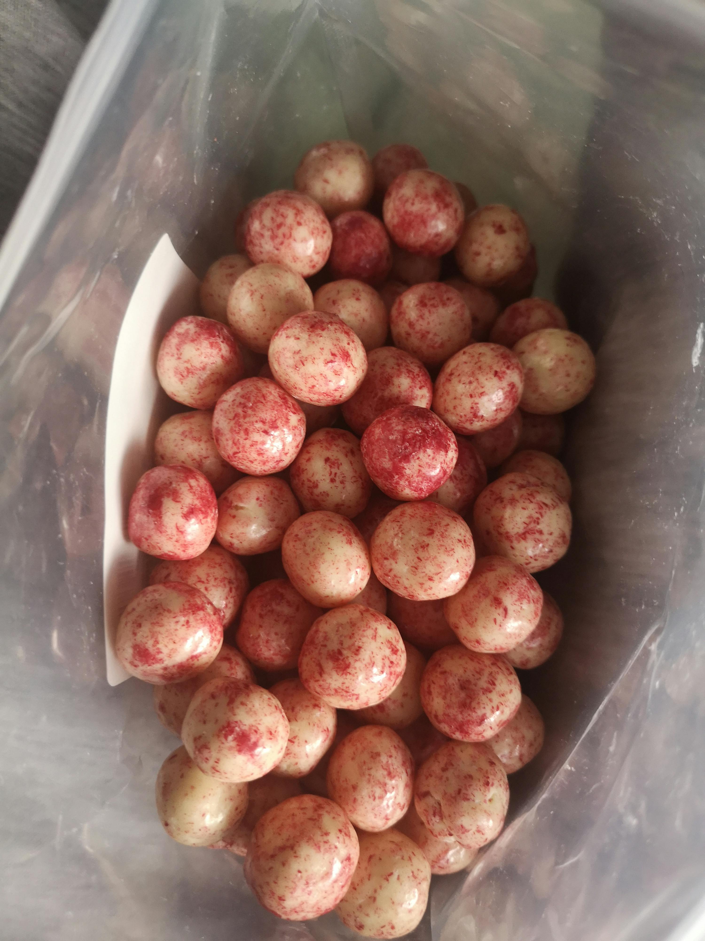 a plastic bag filled with red and white candy balls