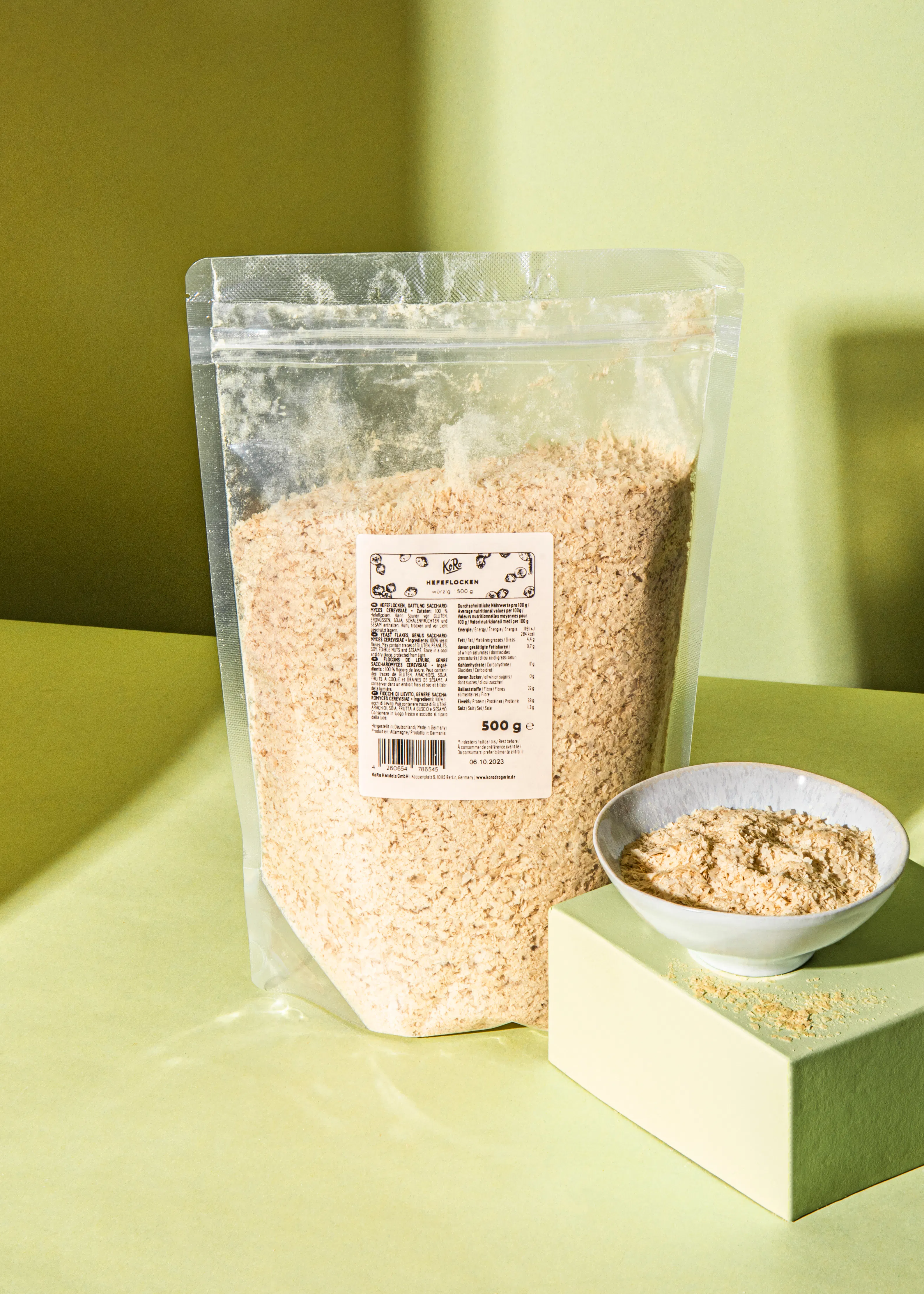 un sac de flocons d' avoine est assis sur une table à côté d' un bol de flocons d' avoine