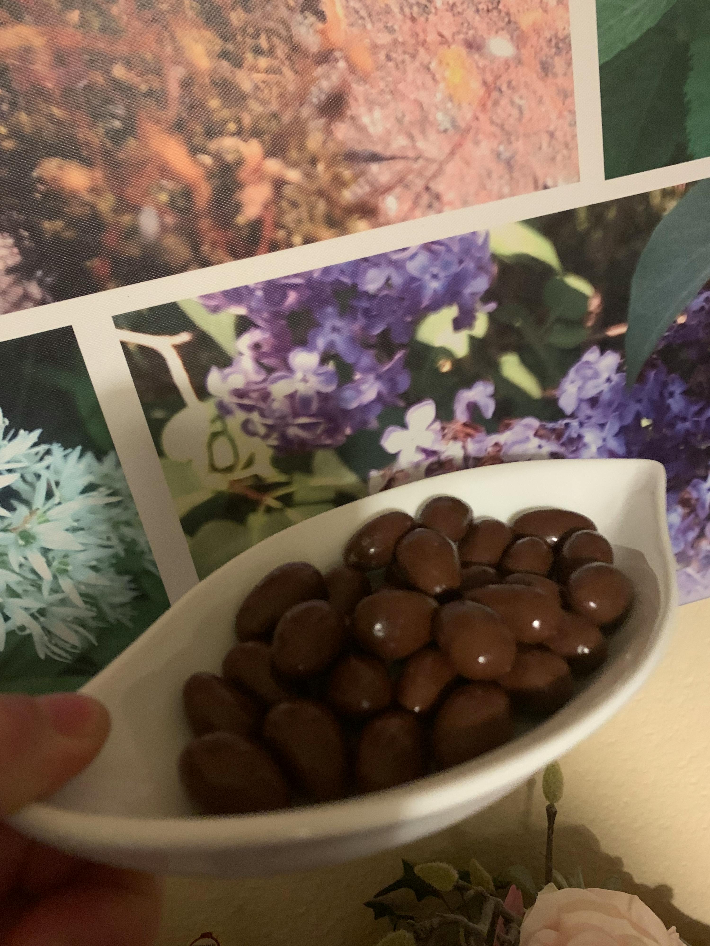 eine Person hält eine weiße Schüssel mit Schokoladenbonbons in der Hand