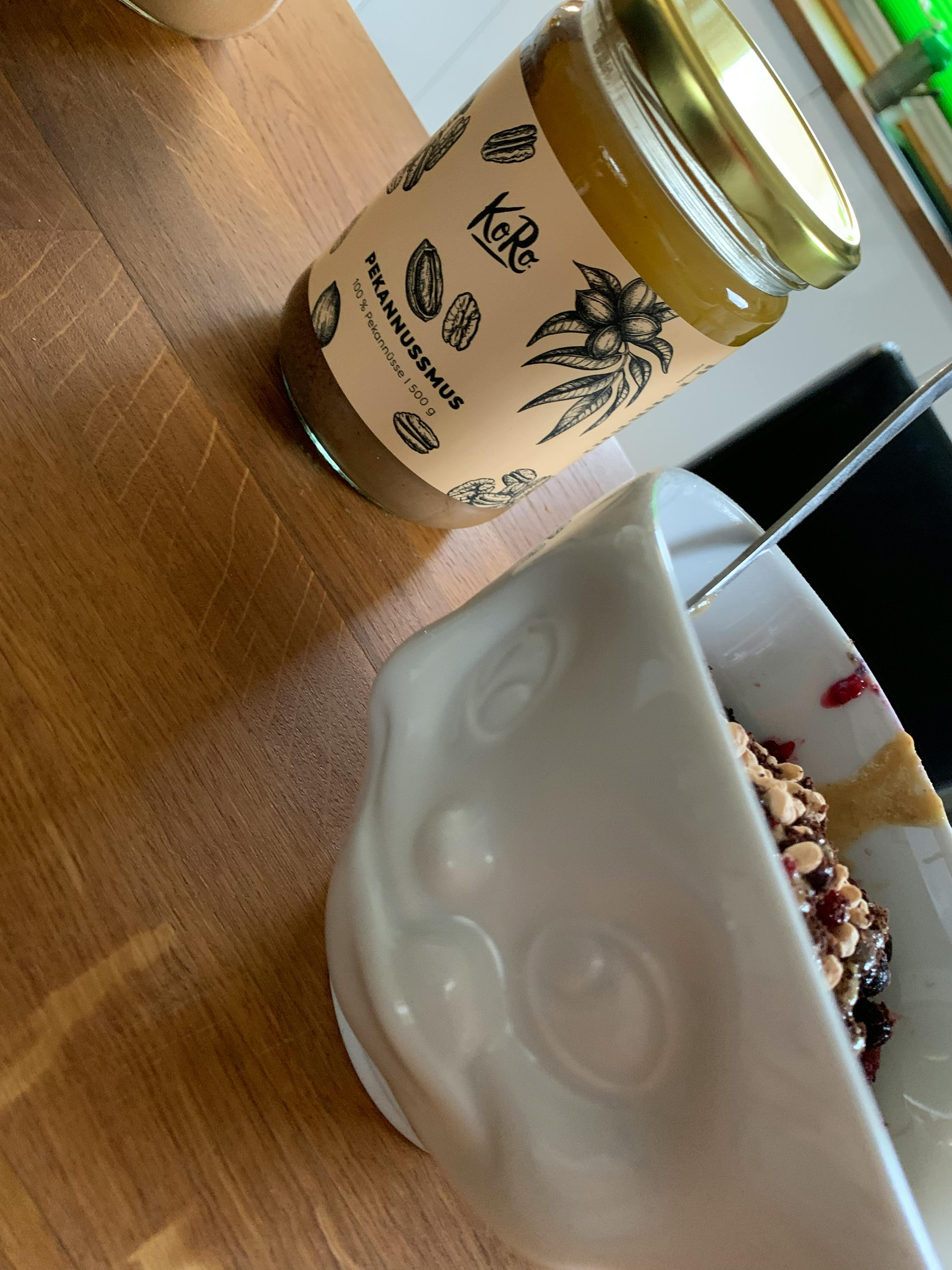 a jar of pecannusmus next to a bowl of food