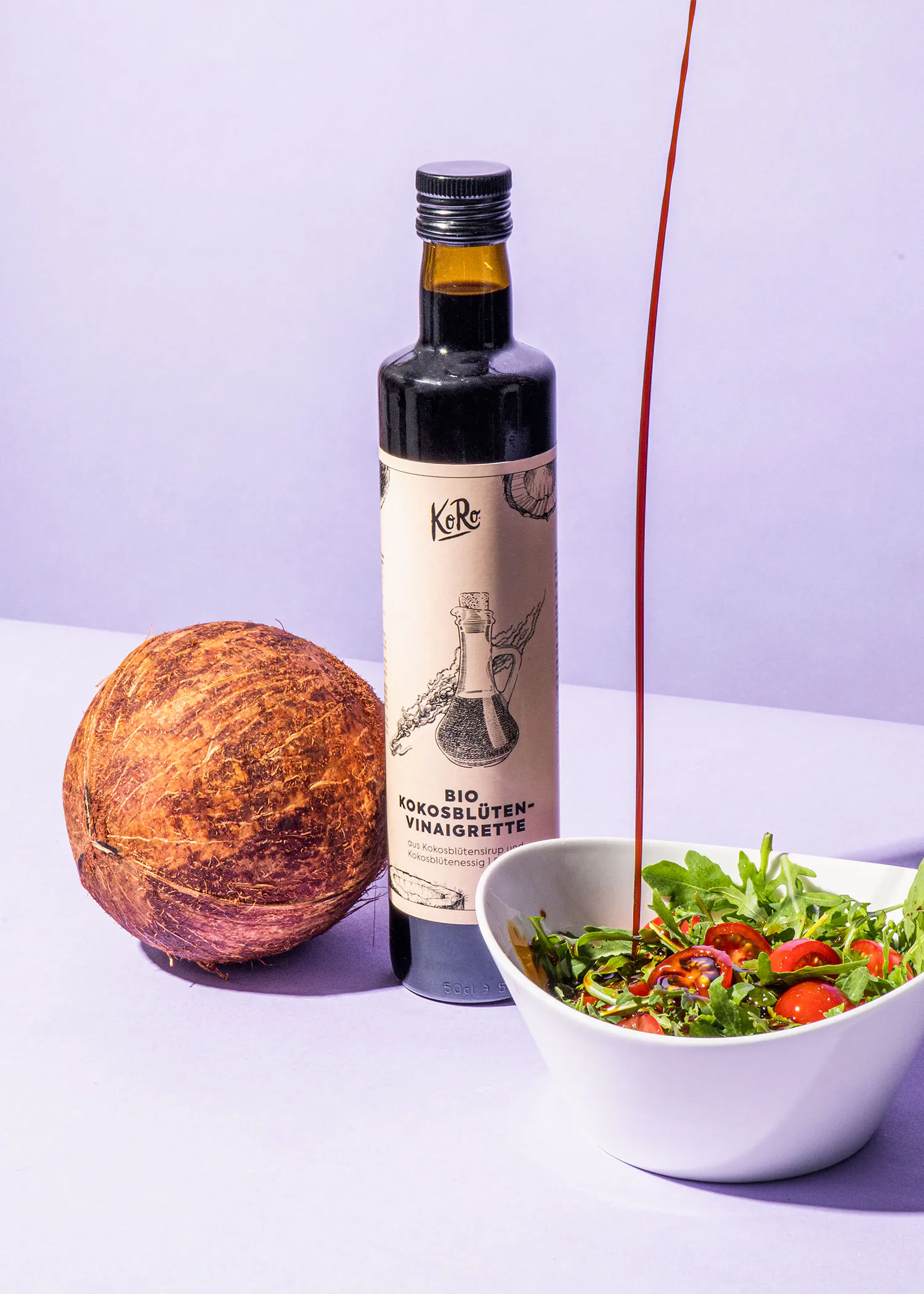 a bottle of bio kokosnuss-vinaigrette next to a coconut