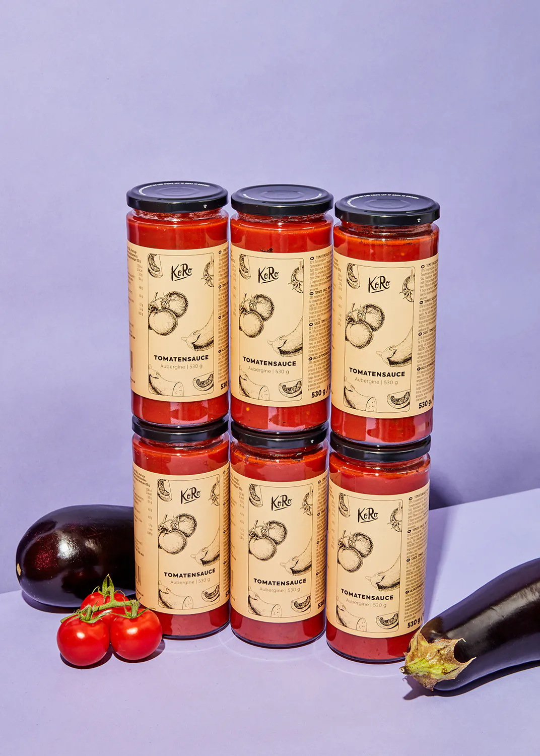 sechs Gläser Tomatensauce stehen nebeneinander auf einem Tisch