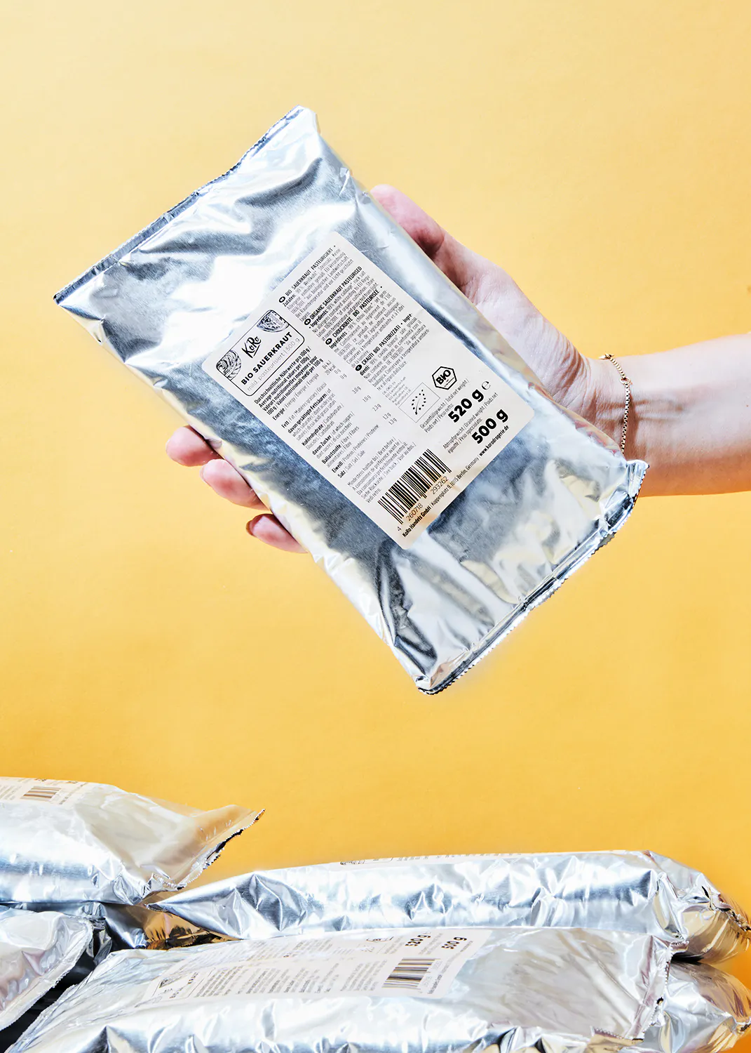 une personne tient un sac de 500 g de cacao bio