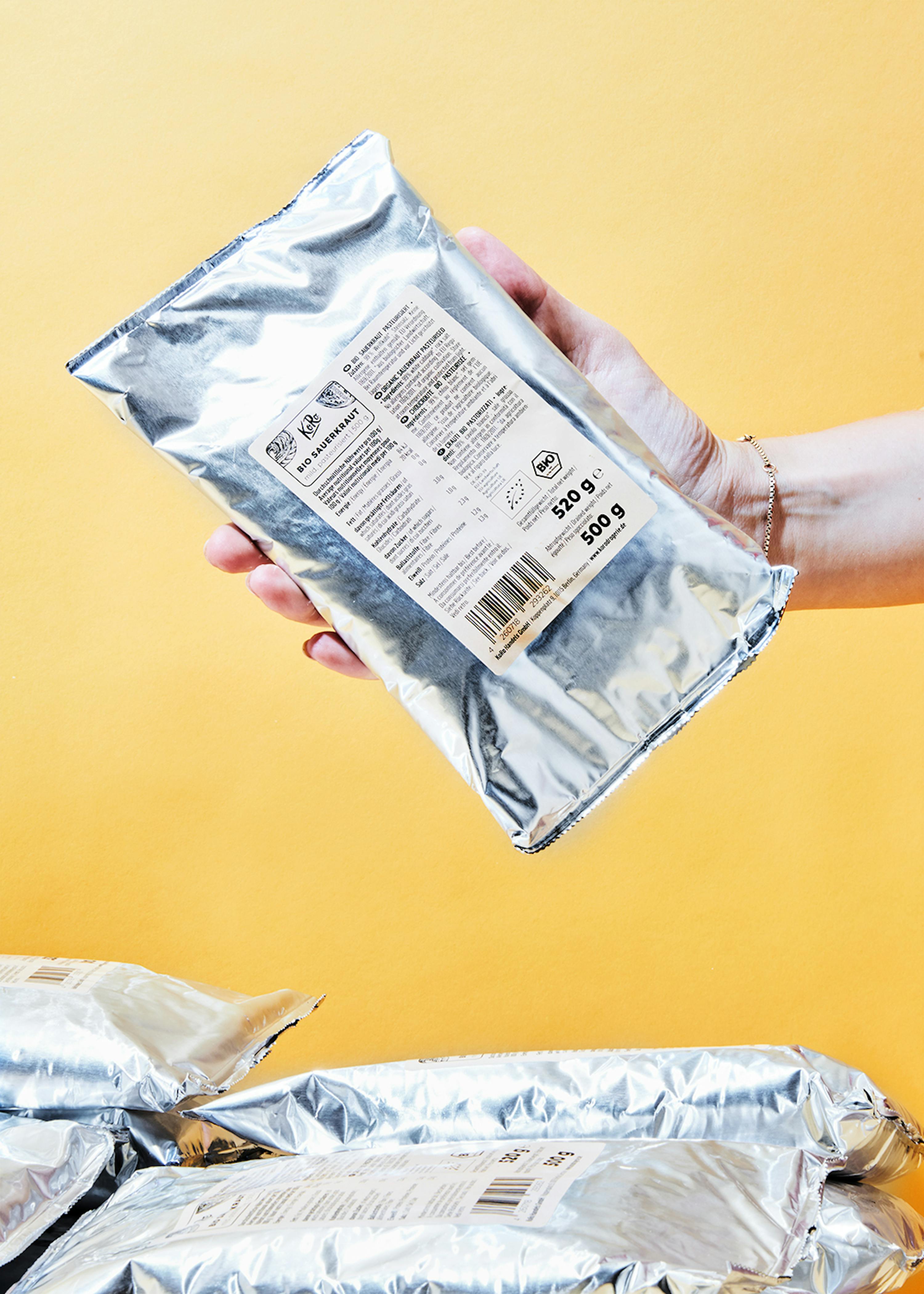 une personne tient un sac de 500 g de cacao bio