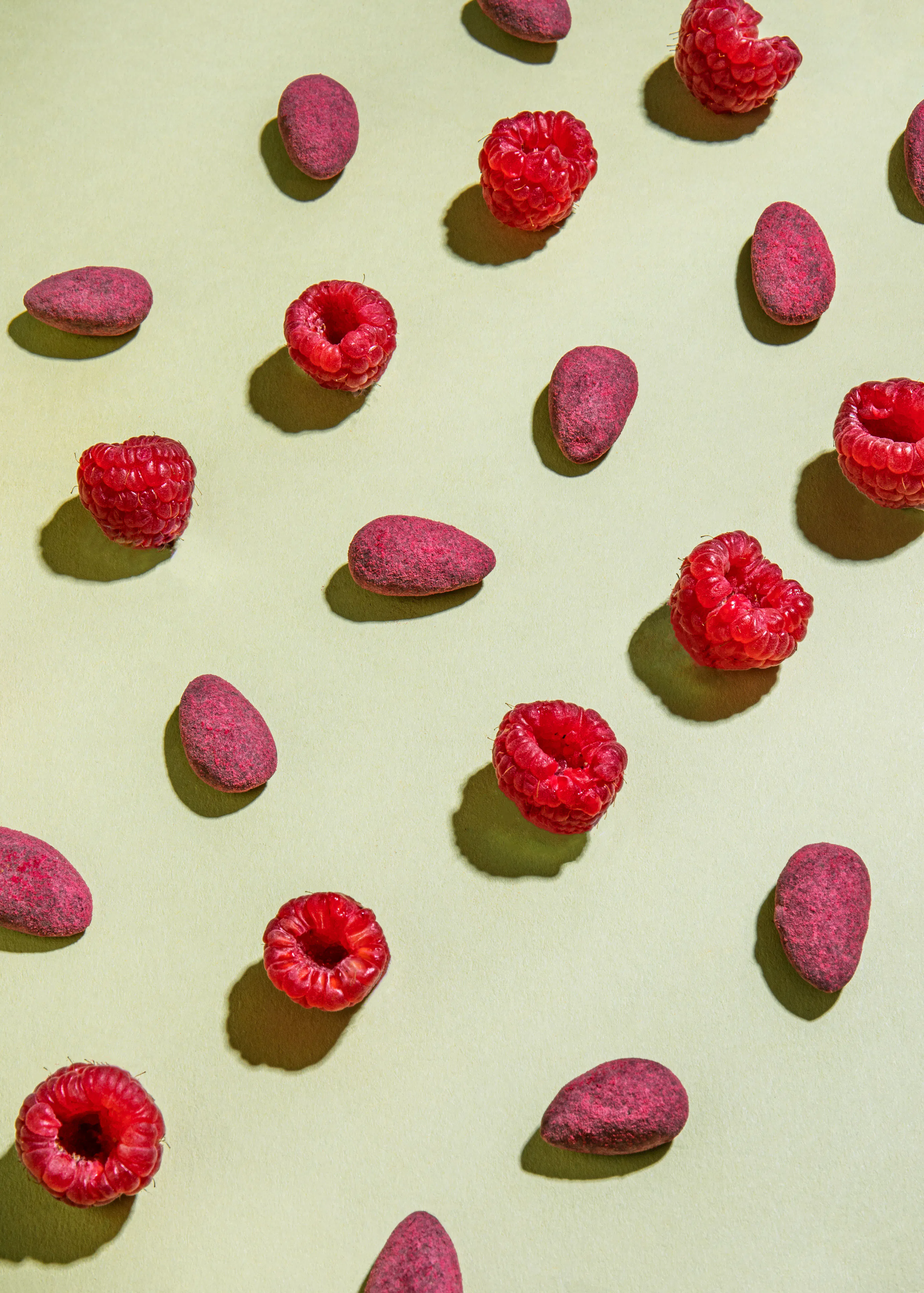 un motif de framboises et de noix sur un fond vert