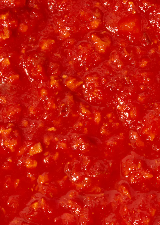 un gros plan d' une sauce rouge avec des morceaux de viande