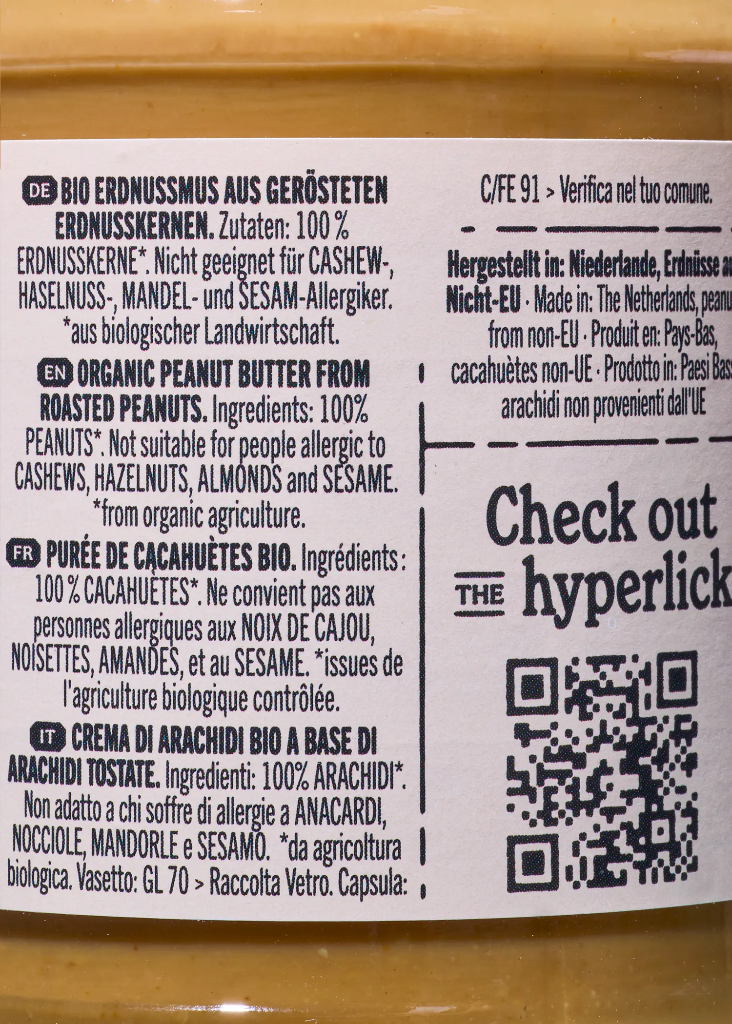 étiquette d'un pot de beurre de cacahuète bio affichant les ingrédients, les avertissements d'allergie en plusieurs langues, l'origine du produit et un code qr.