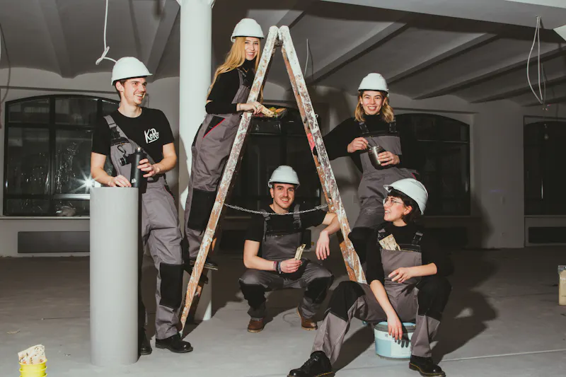 un grupo de trabajadores de la construcción posando para una foto con una escalera en el medio