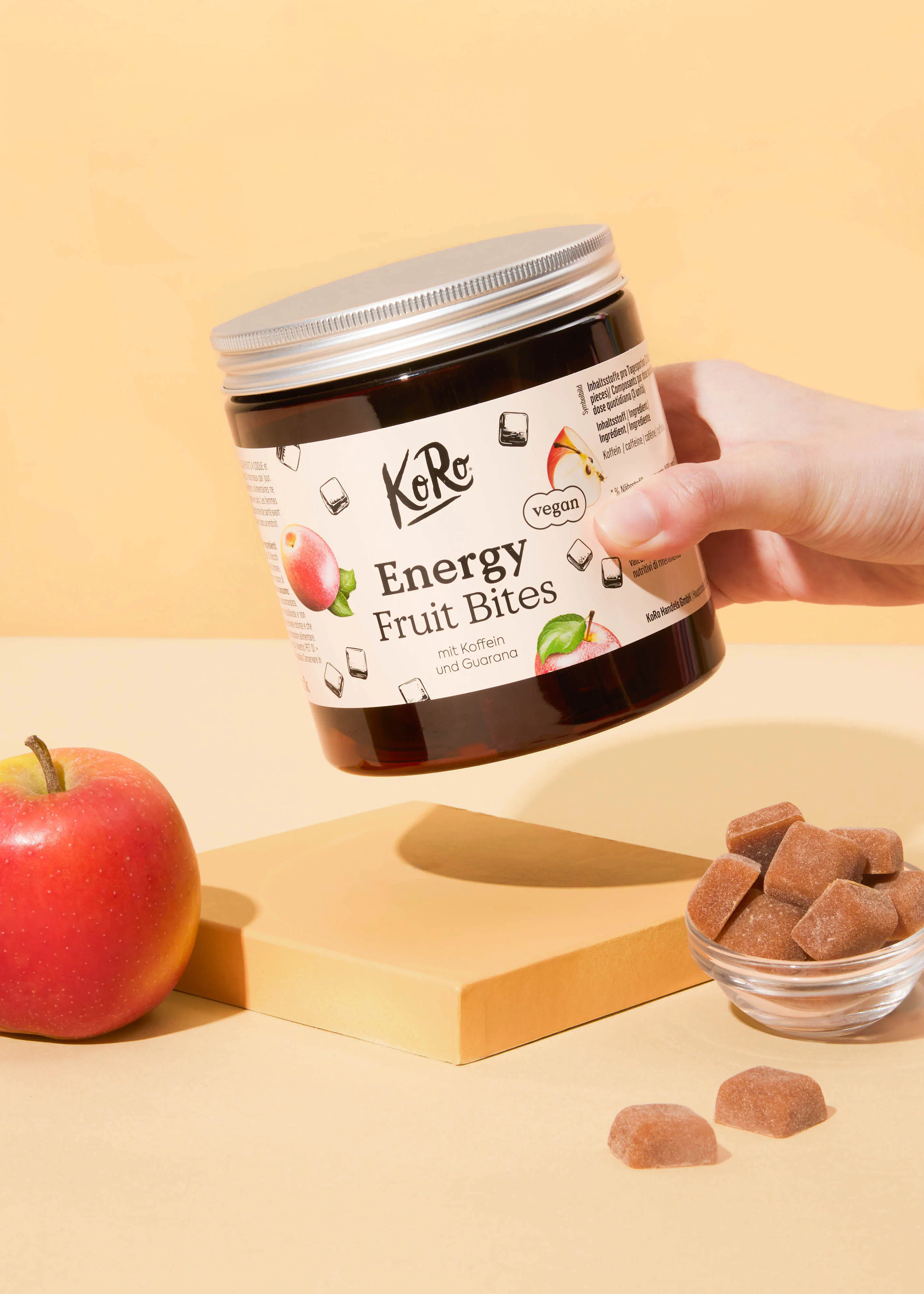 une personne tient un bocal de bonbons énergétiques à la pomme et à la guarana