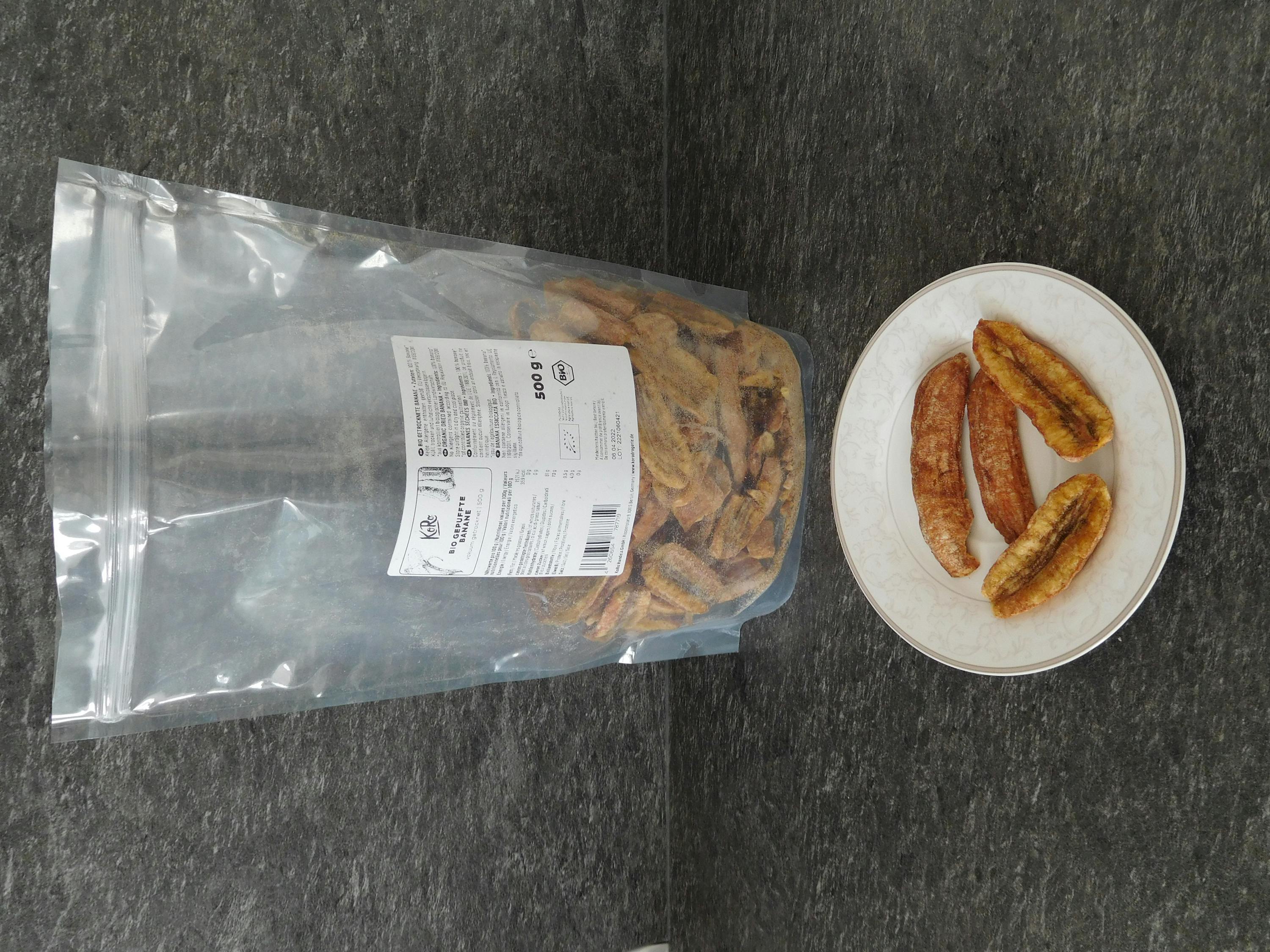 a bag of dried bananas next to a plate of dried bananas